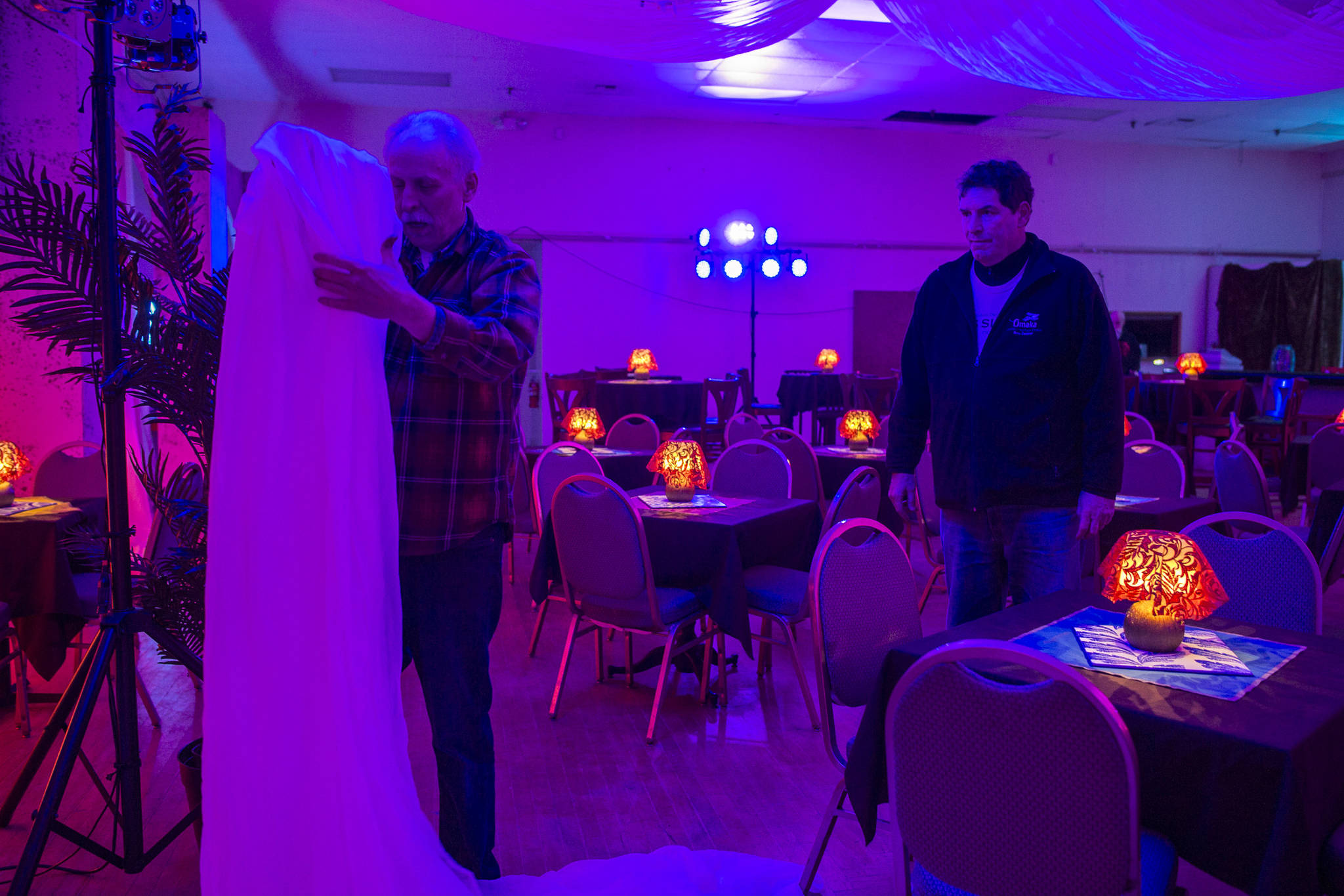 Juneau Lyric Opera boardmember John Clough, right, watches as set designer Nathan Rodda creates Rick’s Cafe Americain at the Rockwell Ballroom for “Here’s Looking at You, Casablanca” on Monday, Nov. 5, 2018. The show is a presentation by the Juneau Lyric Opera and Gold Town Nickelodeon. (Michael Penn | Juneau Empire)
