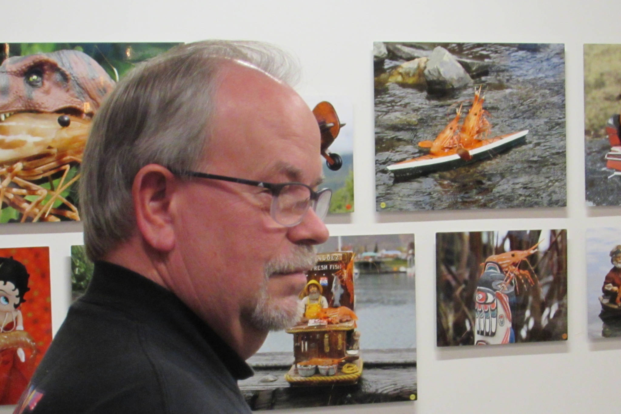 Al Laudert didn’t use Photoshop or any other editing software to create the photos displayed behind him. The Shrimp Whisperer of Valdez instead carefully plans photos before catching shrimp and posing them for his pictures. (Ben Hohenstatt | Capital City Weekly)