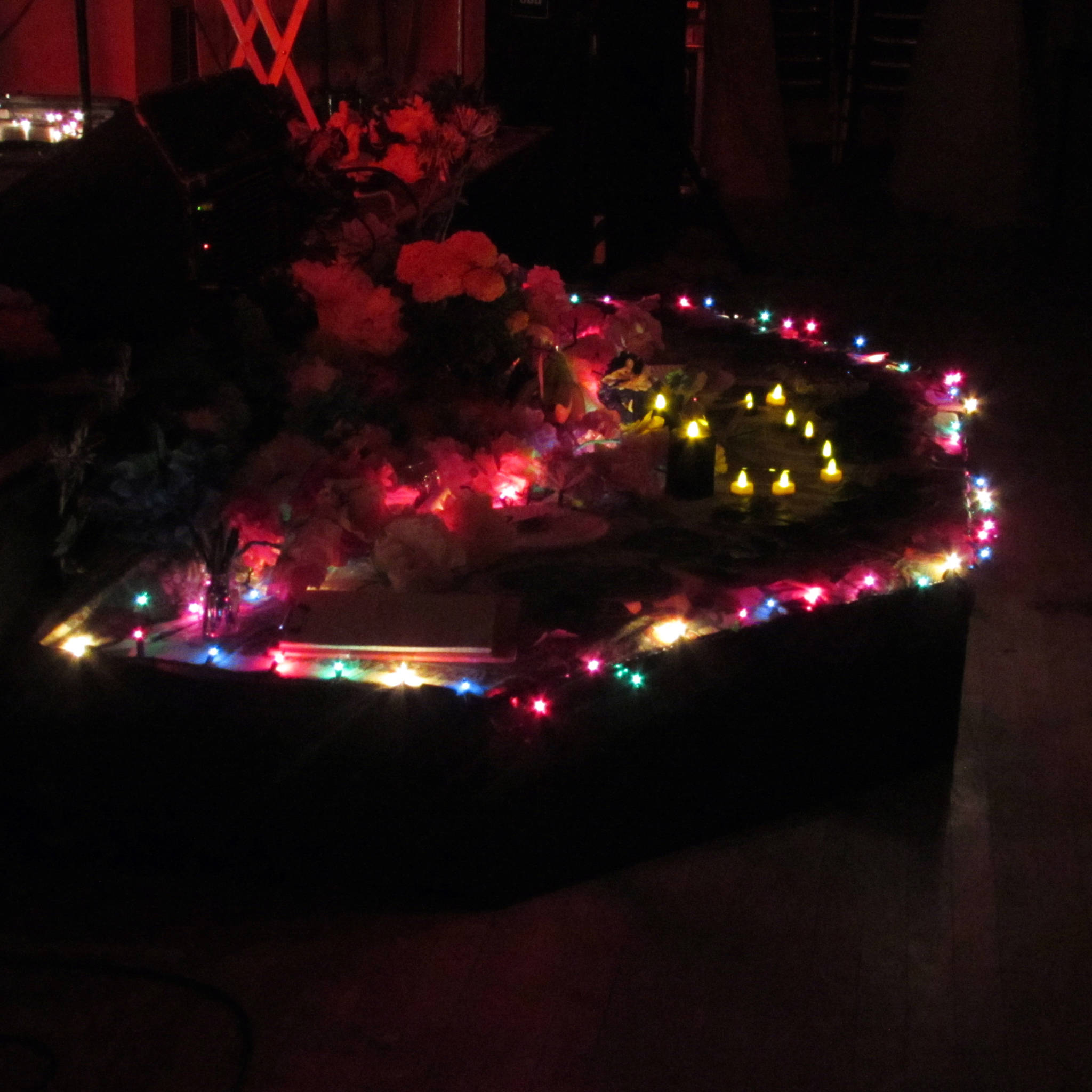 A lit-up altar sat in front of the stage during the Skull Party. George C. Kuhar, lead vocalist and guitar player for Playboy Spaceman, encouraged attendees to leave something in memory of a loved one on the altar, or write down the name of someone deceased on a clipboard at the altar. Kuhar added a letter written to his late father during the show. Ben Hohenstatt | Capital City Weekly)