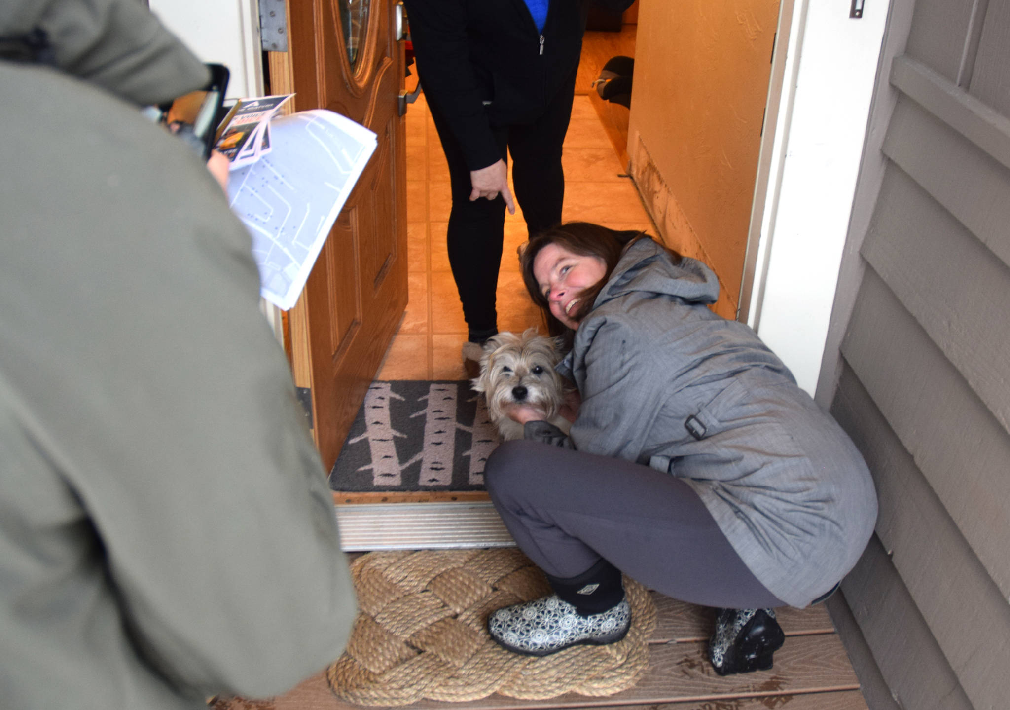Alyse Galvin, Alaska’s independent candidate for U.S. House of Representatives, hugs a dog while going door to door for support Sunday, Nov. 4, 2018 in the Mendenhall Valley. Galvin was in Juneau for a final campaign stop ahead of the election. (James Brooks | Juneau Empire)