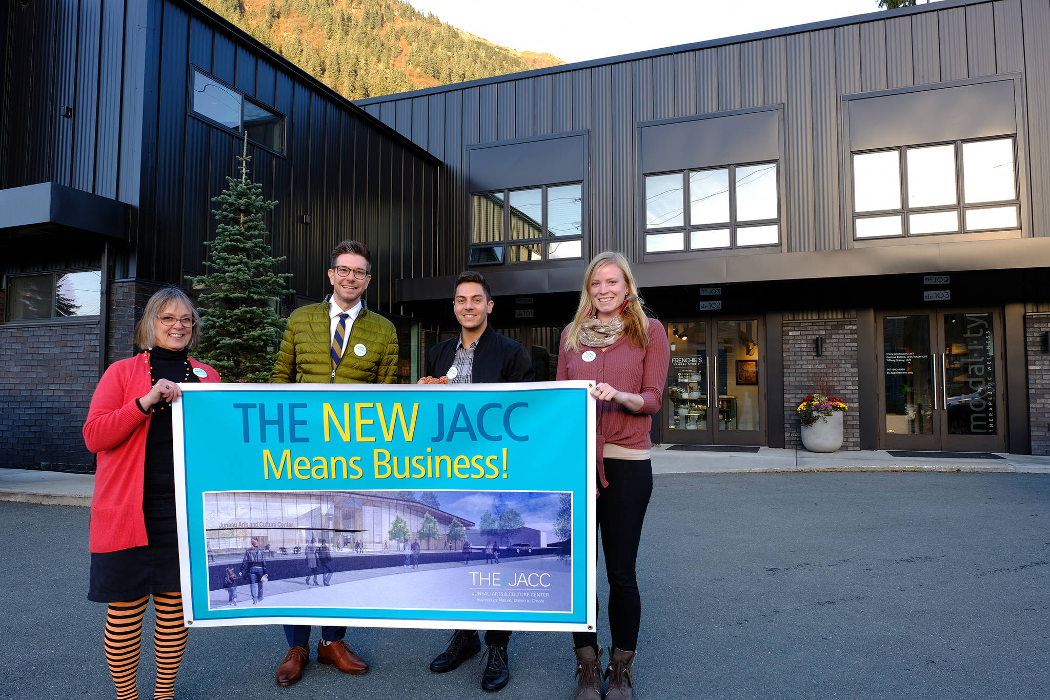 Juneau Arts & Humanities Council Executive Director Nancy DeCherney, Jeremy Bauer and Jason Clifton of Bauer/Clifton Interiors and fundraising assistant manager for the New JACC Rachelle Bonnet stand with a New JACC banner. Bauer and Clifton are the latest major donors to the proposed project. (Courtest Photo | For the JAHC)
