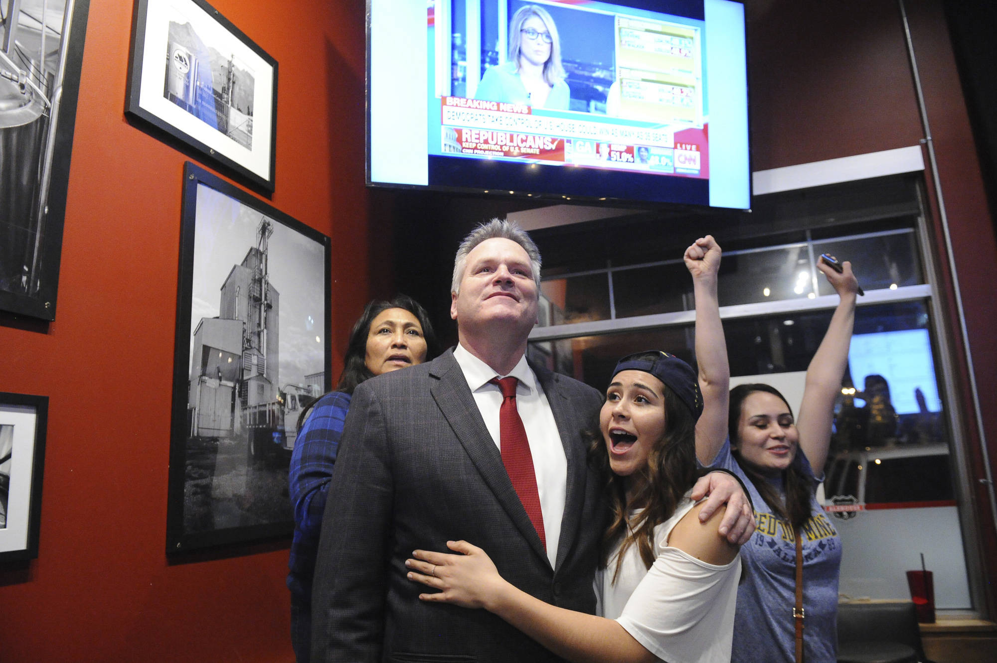 Republican gubernatorial candidate Mike Dunleavy reacts to early favorable election returns Tuesday, Nov. 6, 2018 In Anchorage, Alaska. With Dunleavy are from left, his wife Rose and daughters Ceil and Maggie. (AP Photo/Michael Dinneen)