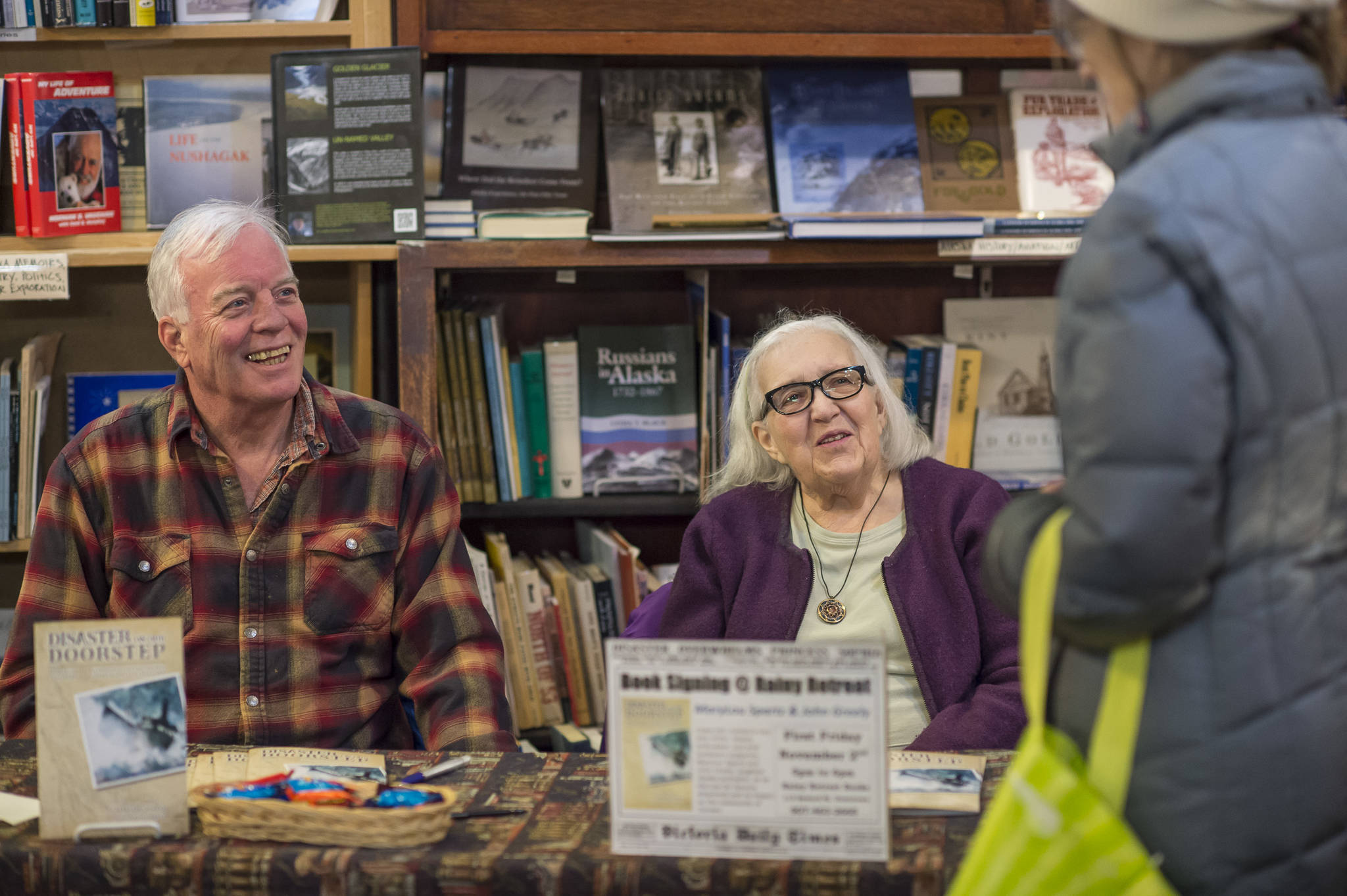 MaryLou Spartz, center, and co-author John Greely talk with Suzi Fowler as they sign their new book on the community of Juneau’s reaction to the sinking of the famous Princess Sophia at Rainy Retreat Books for First Friday on Friday, Nov. 2, 2018. Submissions for the next First Friday are due to the JAHC Nov. 21. (Michael Penn | Juneau Empire)