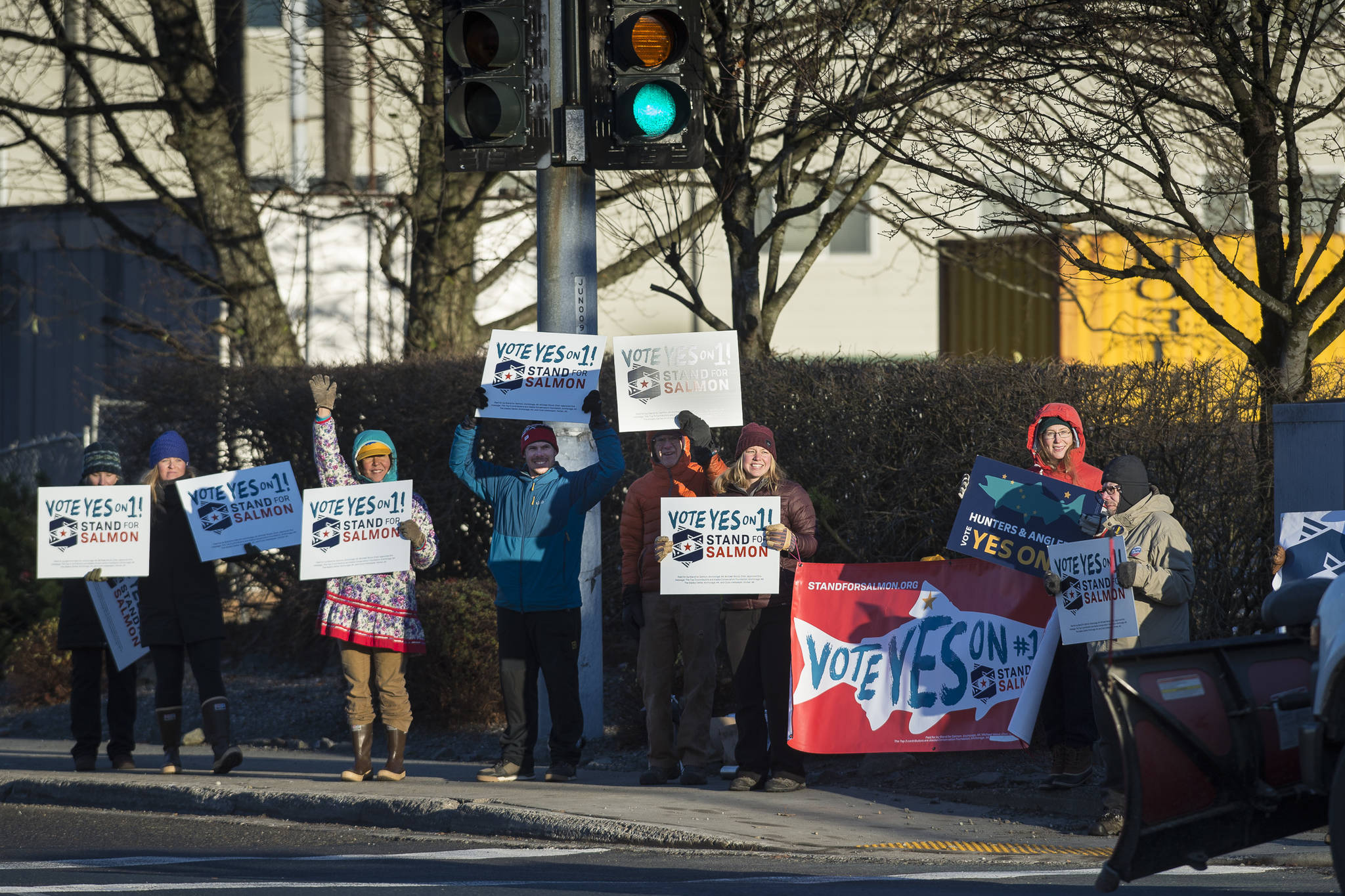 Ballot Measure 1 supporters wave signs for morning commuters at the corner of Egan Drive and 10th Street on Election Day, Tuesday, Nov. 6, 2018. (Michael Penn | Juneau Empire)
