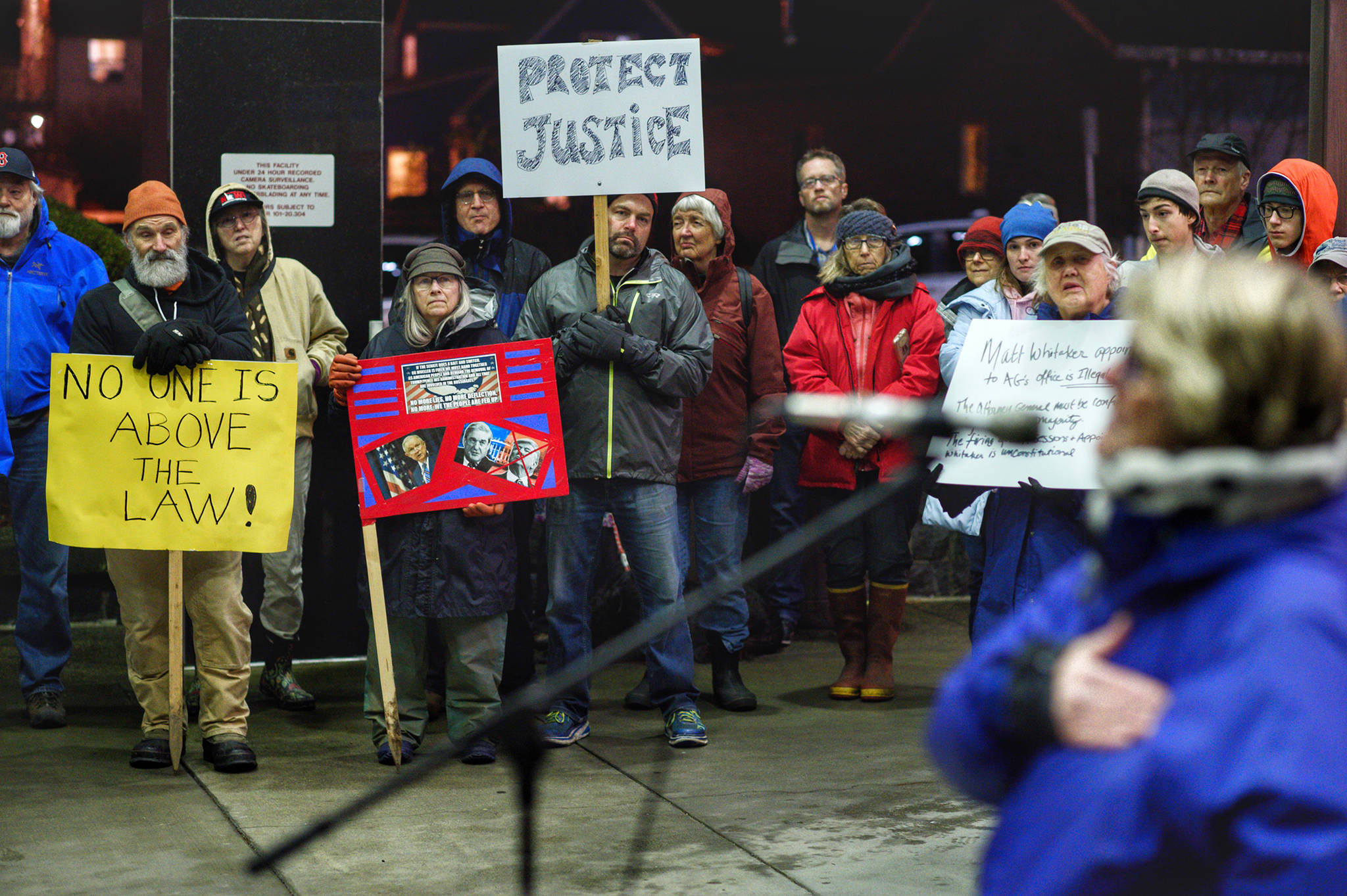 Nearly 100 people show up to protest President Donald Trump’s appointment of Matthew Whitaker, as former Rep. Beth Kerttula speaks outside the Federal Building on Thursday. Many protesters believe Whitaker’s hiring could jeopardize the Mueller investigation into possible connections between Trump’s presidential campaign and the Russian government. (Michael Penn | Juneau Empire)