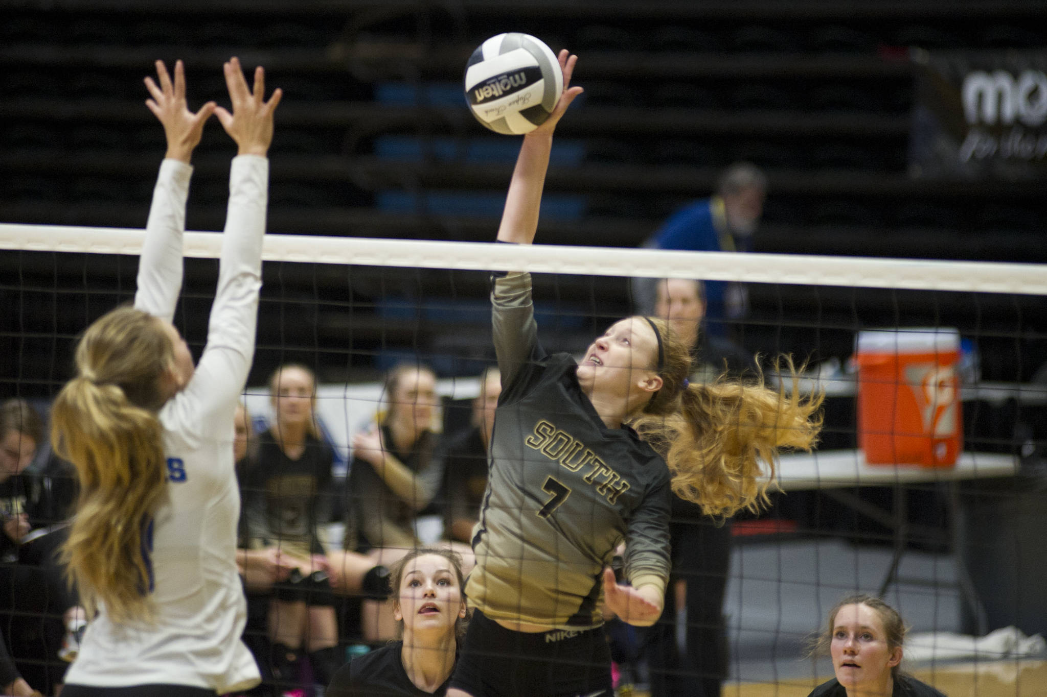 South Anchorage High School sophomore Kinsey Schilke spikes the ball as Thunder Mountain’s Lily Smith goes up for the block at the ASAA/First National Bank Alaska 3A/4A Volleyball State Championships on Friday at the Alaska Airlines Center in Anchorage. South won 3-0 (25-10, 25-21, 25-12). (Nolin Ainsworth | Juneau Empire)