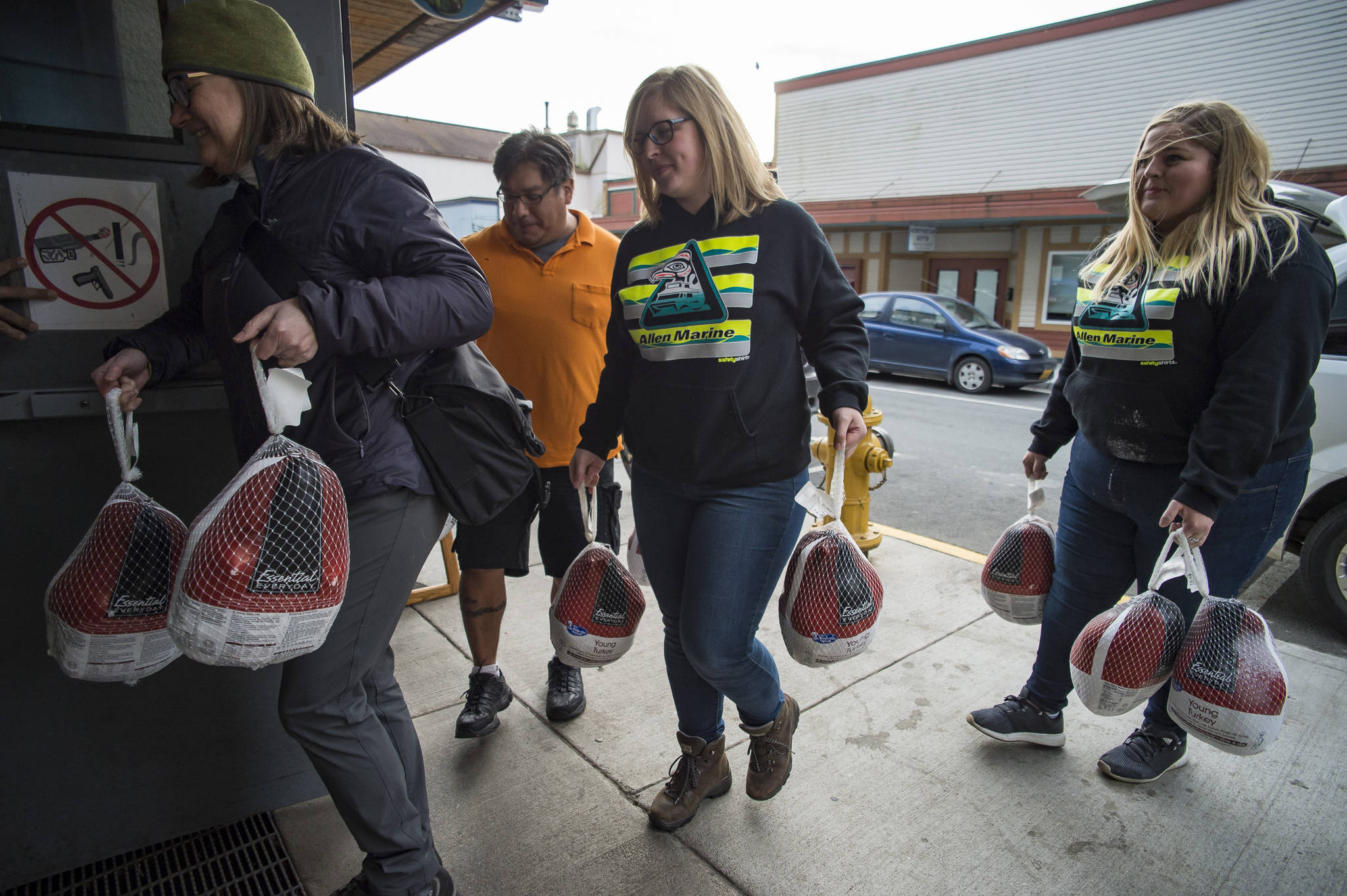 Cassandra Strahin, center, and Nicole Huntsman, both of Allen Marine, get help from Malou Peabody, left, and Clarence Milton as they deliver 30 frozen turkeys to the Glory Hole on Monday, Nov. 6, 2017. (Michael Penn | Juneau Empire)