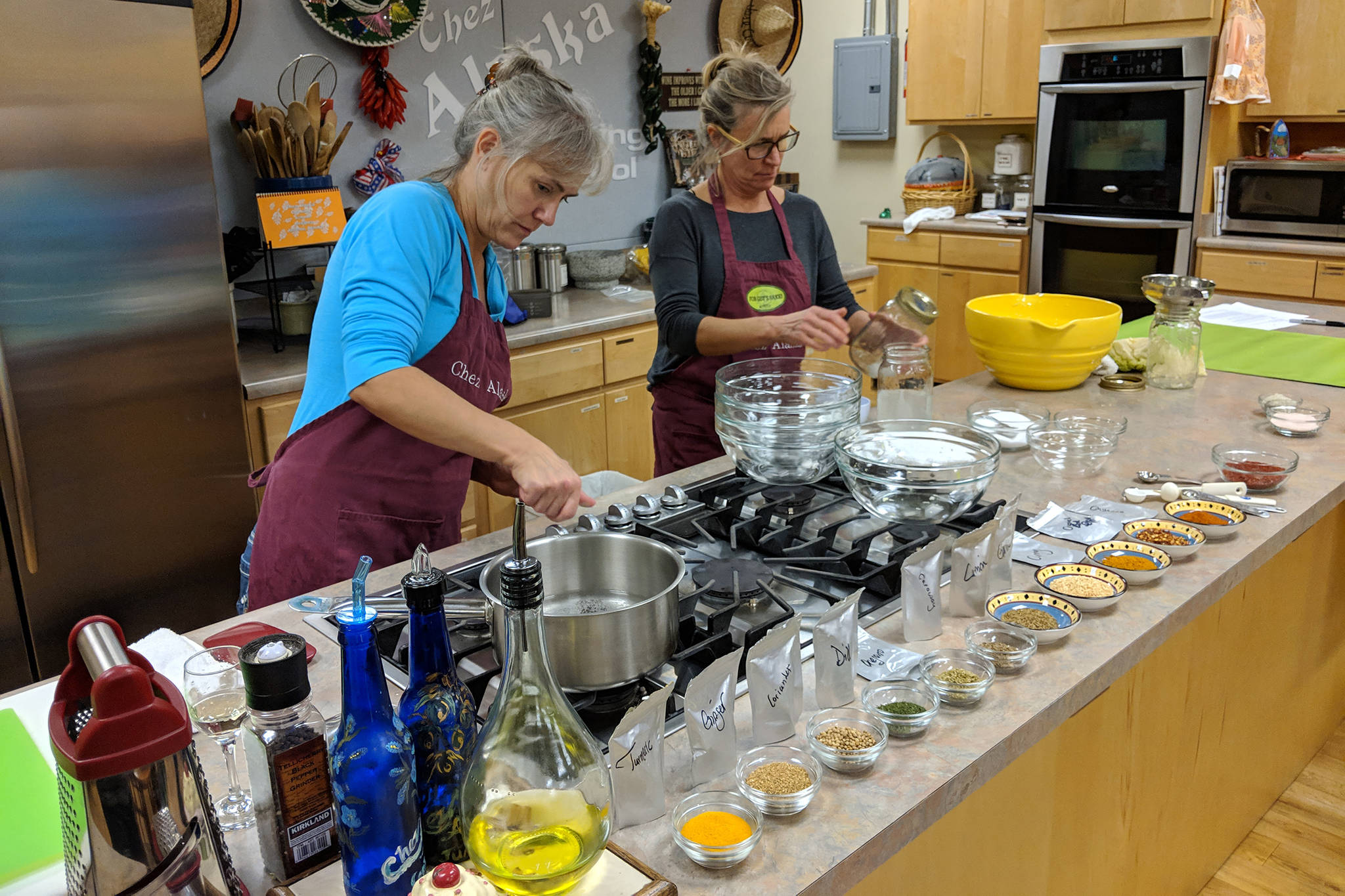 Julie Hamilton, assistant professor of accounting for University of Alaska Southeast, and Julie O’Brien, owner of Firefly Kitchens, ready equipment and ingredients for a fermented foods demonstration. Fermentation 101 was a UAS Alumni and Friends Association event that gave those in attendance hands-on practice with fermented foods Friday, Nov. 9 at Chez Alaska Cooking School. (Ben Hohenstatt | Capital City Weekly)