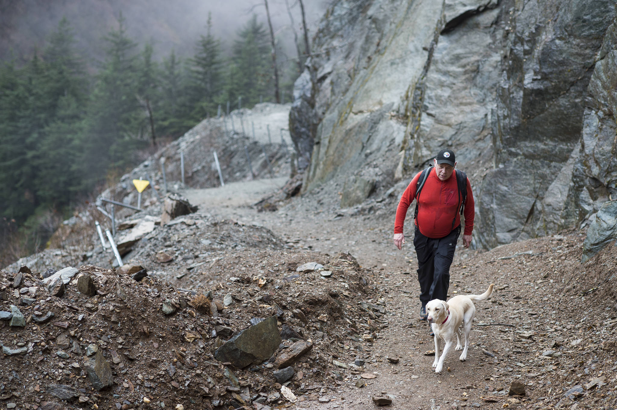 Andy Smoker hikes up Perseverance Trail with his dog, Linda, on Friday, Nov. 9, 2018. Work was completed recently to clear rock and debris along the trail. (Michael Penn | Juneau Empire)