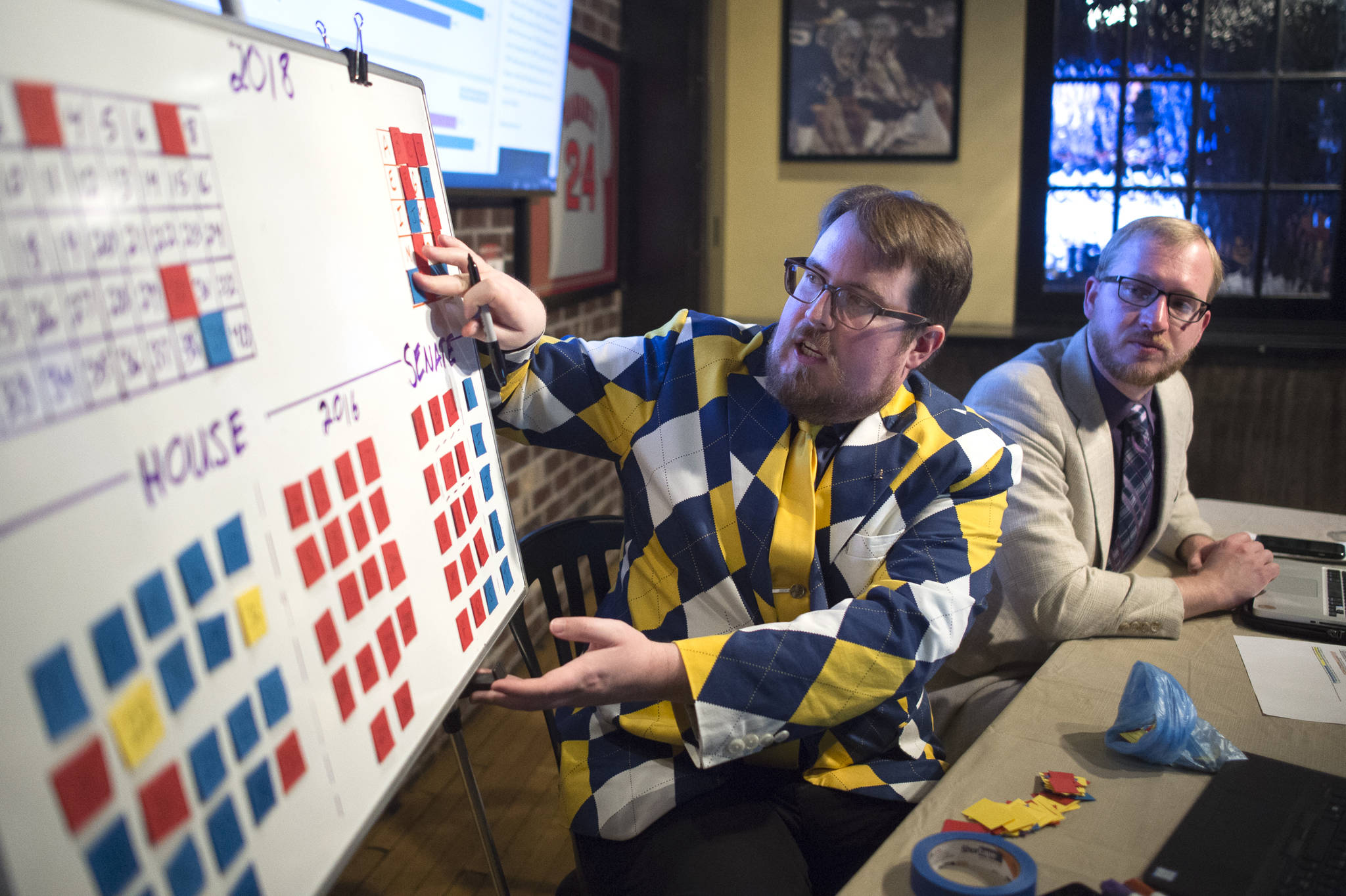 Juneau Empire reporters James Brooks, left, and Alex McCarthy keep track of Alaska legislative races from the Empire’s Election Central at McGivney’s Sports Bar and Grill on Tuesday, Nov. 6, 2018. (Michael Penn | Juneau Empire)