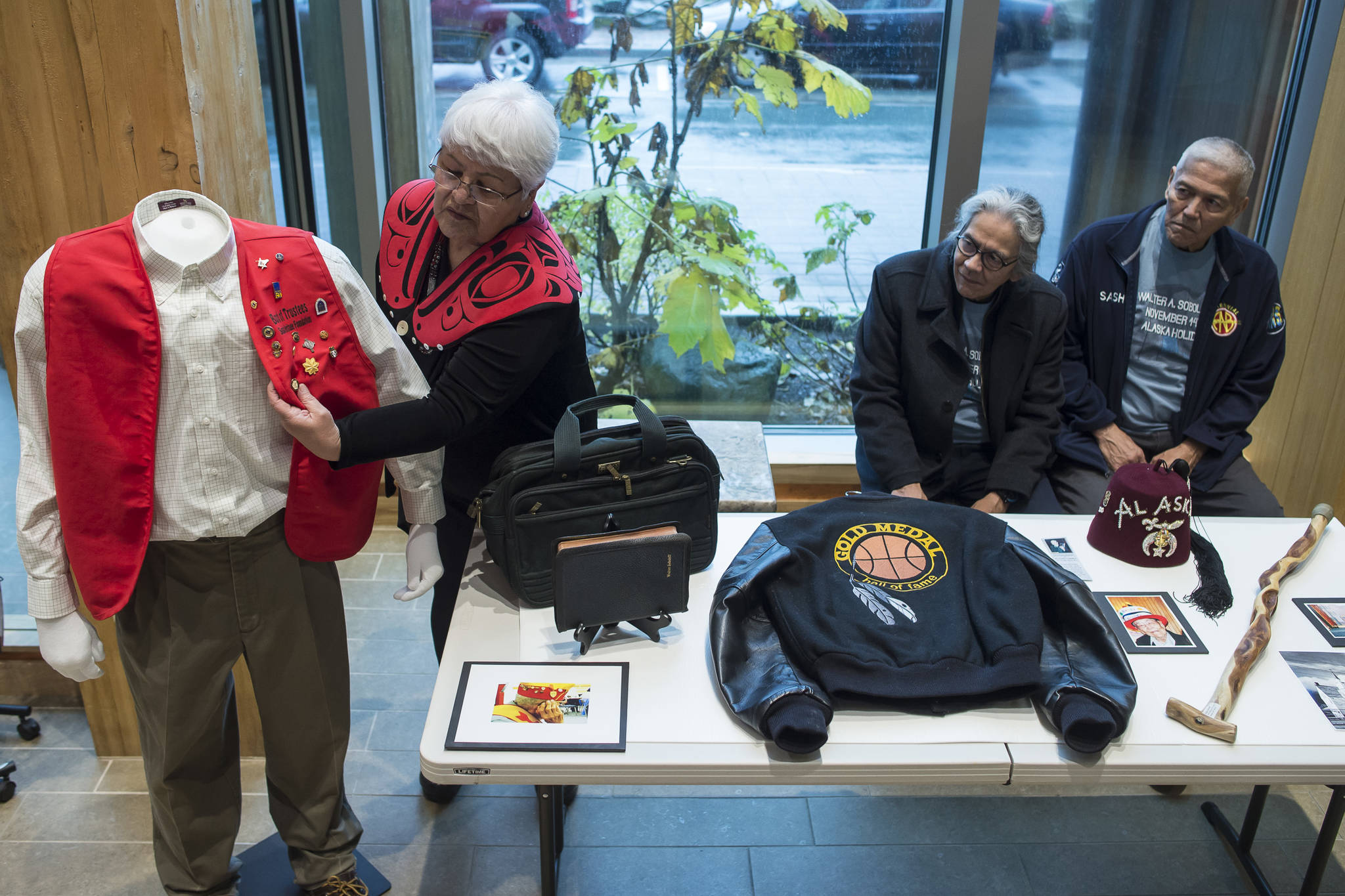 Janet Burke talks about some of her father’s things on display at the Walter Soboleff Center as her brothers, Walter Jr., center, and Sasha, watch on Wednesday, Nov. 14, 2018. Nov. 14 was named Dr. Walter Soboleff Day by the Alaska Legislature in 2014. (Michael Penn | Juneau Empire)