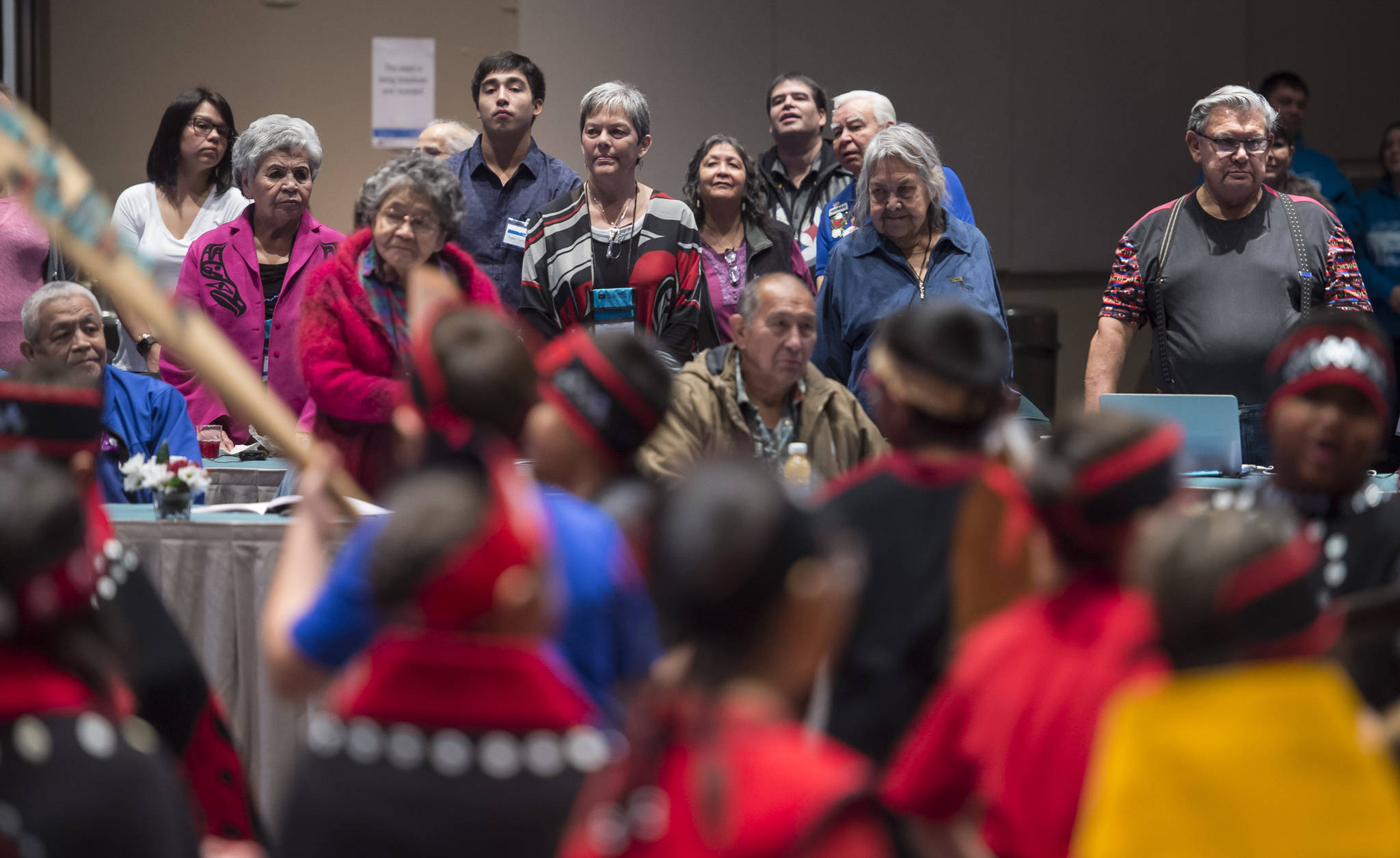Native speakers stand to watch the Tlingit Culture Language and Literacy Dance Group from Harborview Elementary School dance during the Voices of Our Ancestors Language Summit at Centennial Hall on Tuesday, Nov. 13, 2018. (Michael Penn | Juneau Empire)