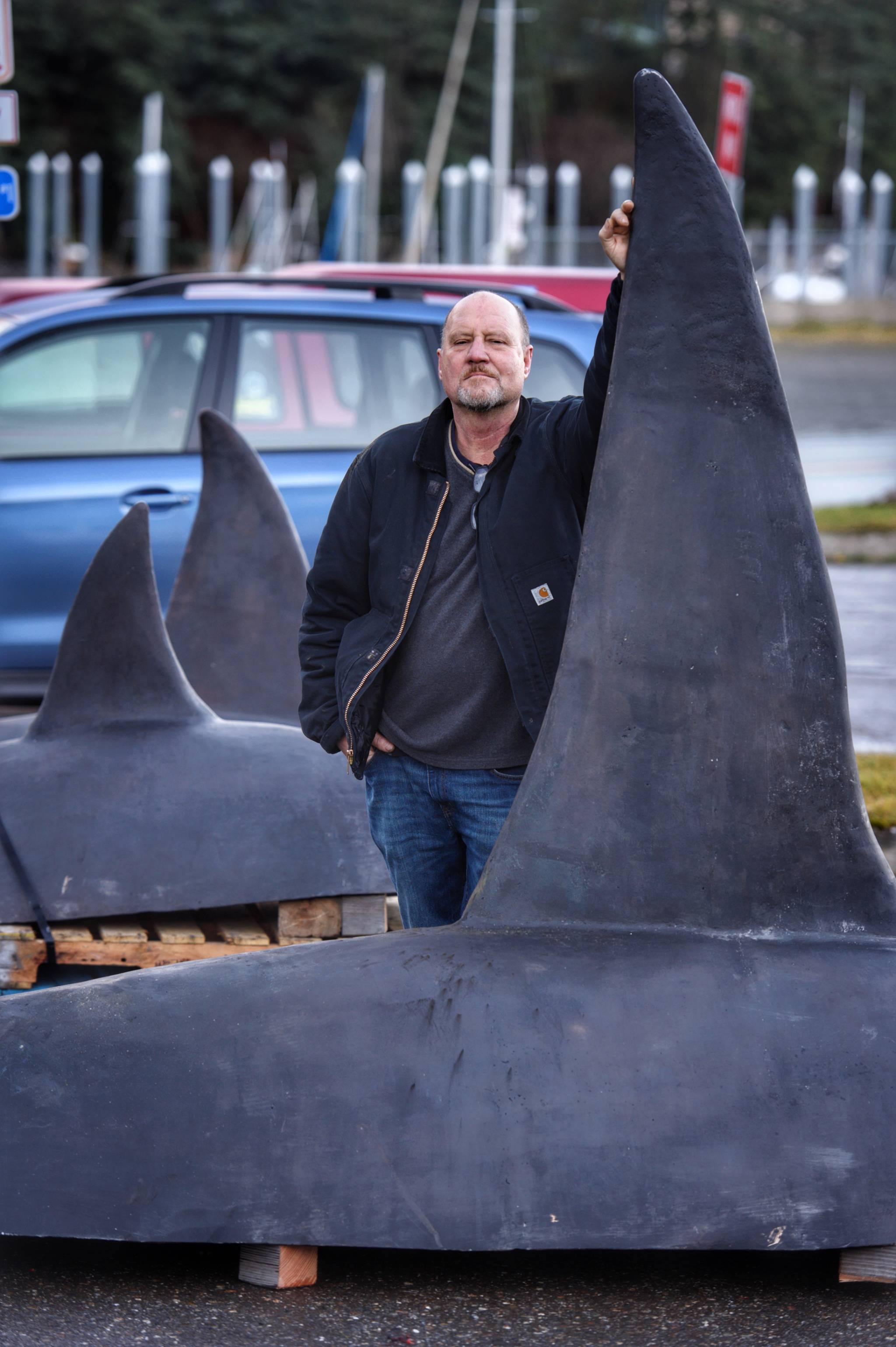 Palmer artist John Coyne stands next to his three orca sculptures ready for installation at the Douglas Fish & Game Building on Thursday, Nov. 15, 2018. (Michael Penn | Juneau Empire)