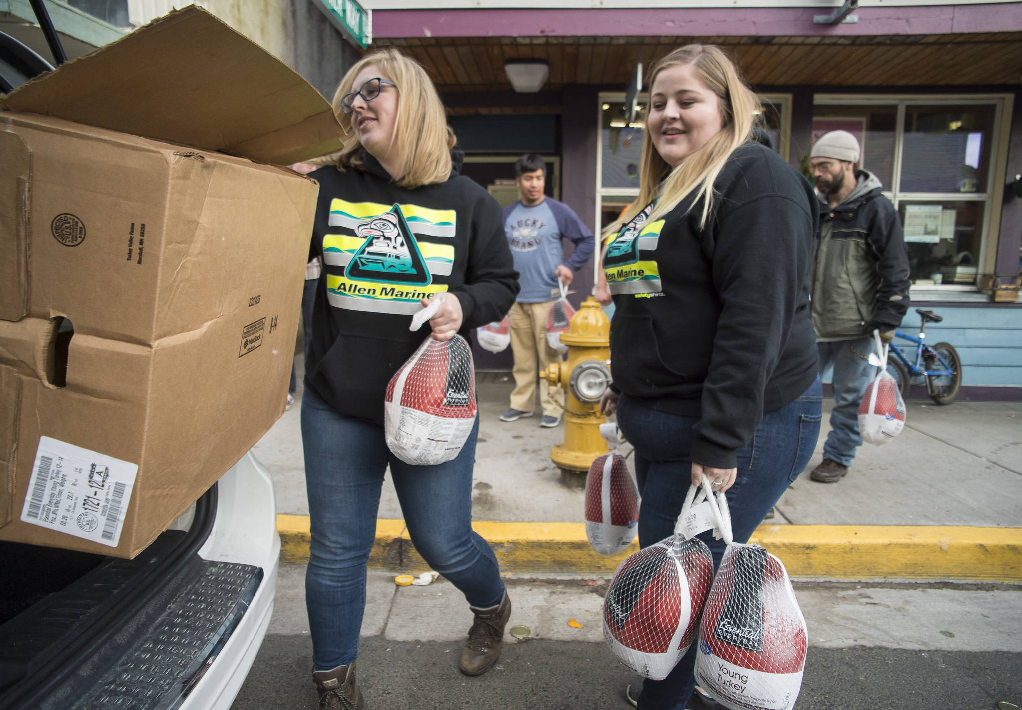Cassandra Strahin, left, and Nicole Huntsman, of Allen Marine, deliver 30 frozen turkeys to the Glory Hole on Monday, Nov. 6, 2017. (Michael Penn | Juneau Empire File)