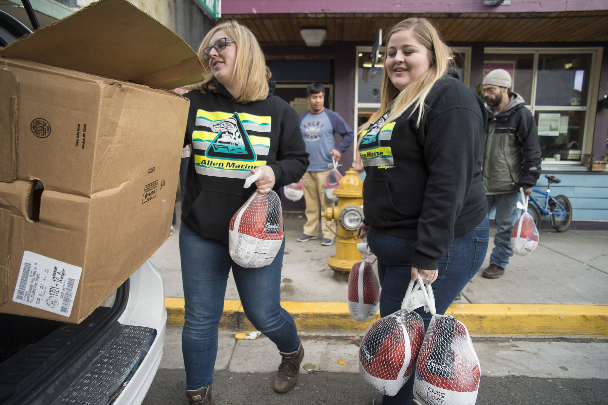 Cassandra Strahin, left, and Nicole Huntsman, of Allen Marine, deliver 30 frozen turkeys to the Glory Hole on Monday, Nov. 6, 2017. (Michael Penn | Juneau Empire File)