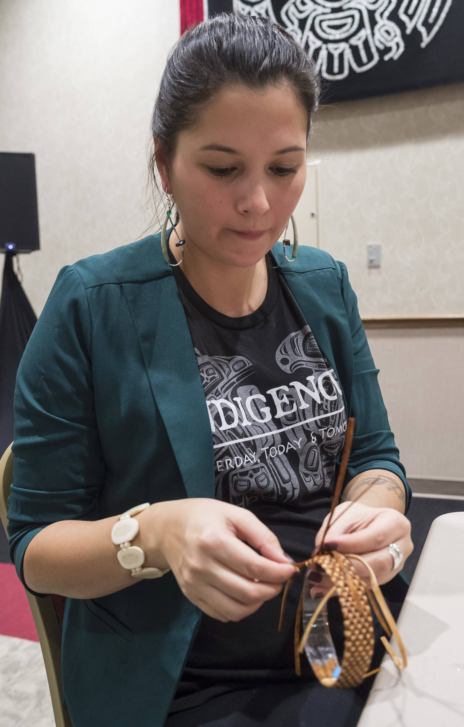 Heather Gatti works on a cedar root braclett at the Celebrating Our Ways of Life for Native American Heritage Month at the Elizabeth Peratrovich Hall on Friday, Nov. 16, 2018. (Michael Penn | Juneau Empire)