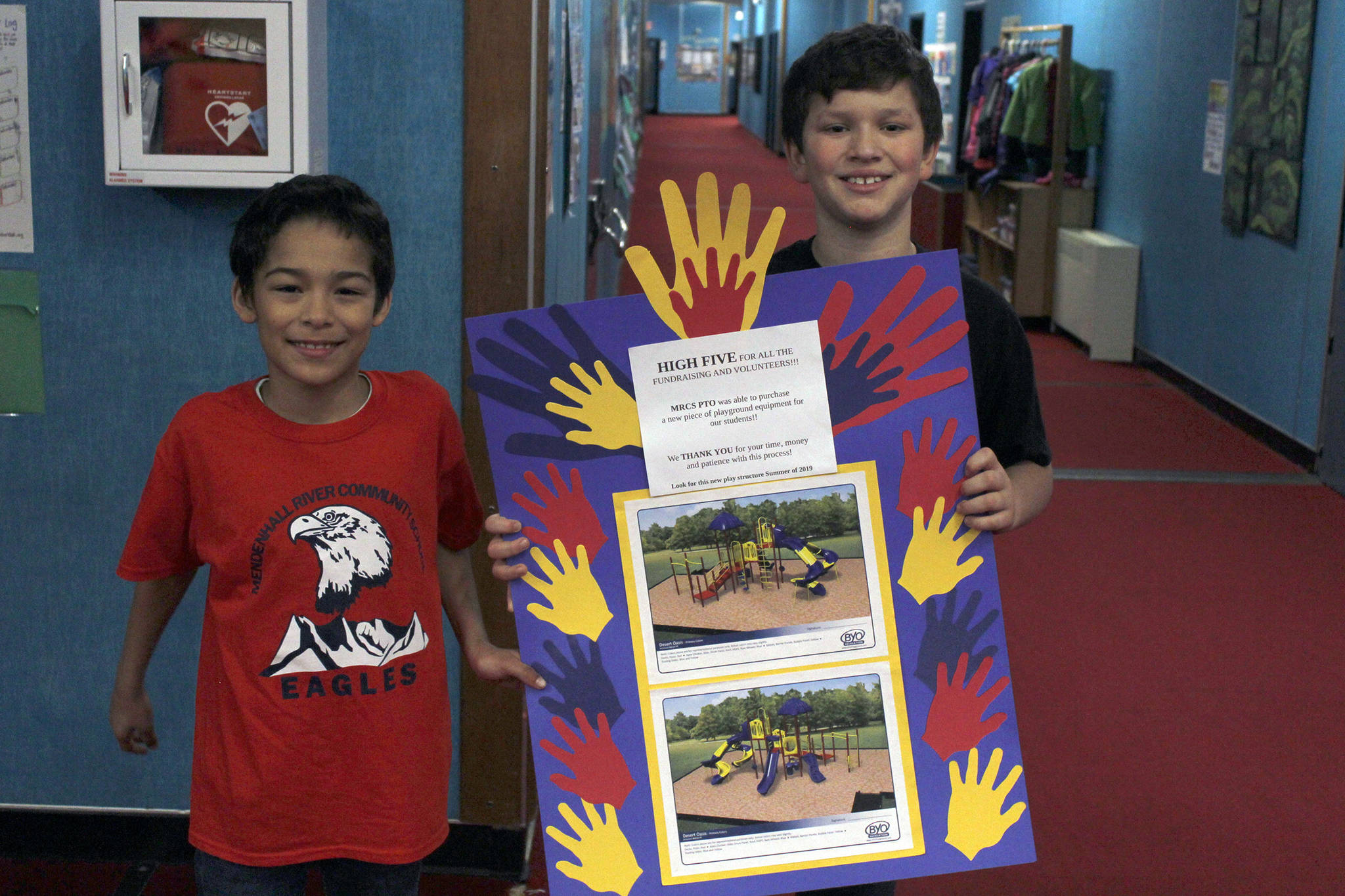 Mendenhall River Community School fourth graders Matthew Acosta-Abreu (left) and Logan Carriker hold a poster that displays a new piece of playground equipment the school is getting.                                 <span class="neFMT neFMT_PhotoCredit">^</span>                                <span class="neFMT neFMT_PhotoCredit"><strong>Alex McCarthy </strong></span>                                <span class="neFMT neFMT_PhotoCredit">| Juneau Empire</span>