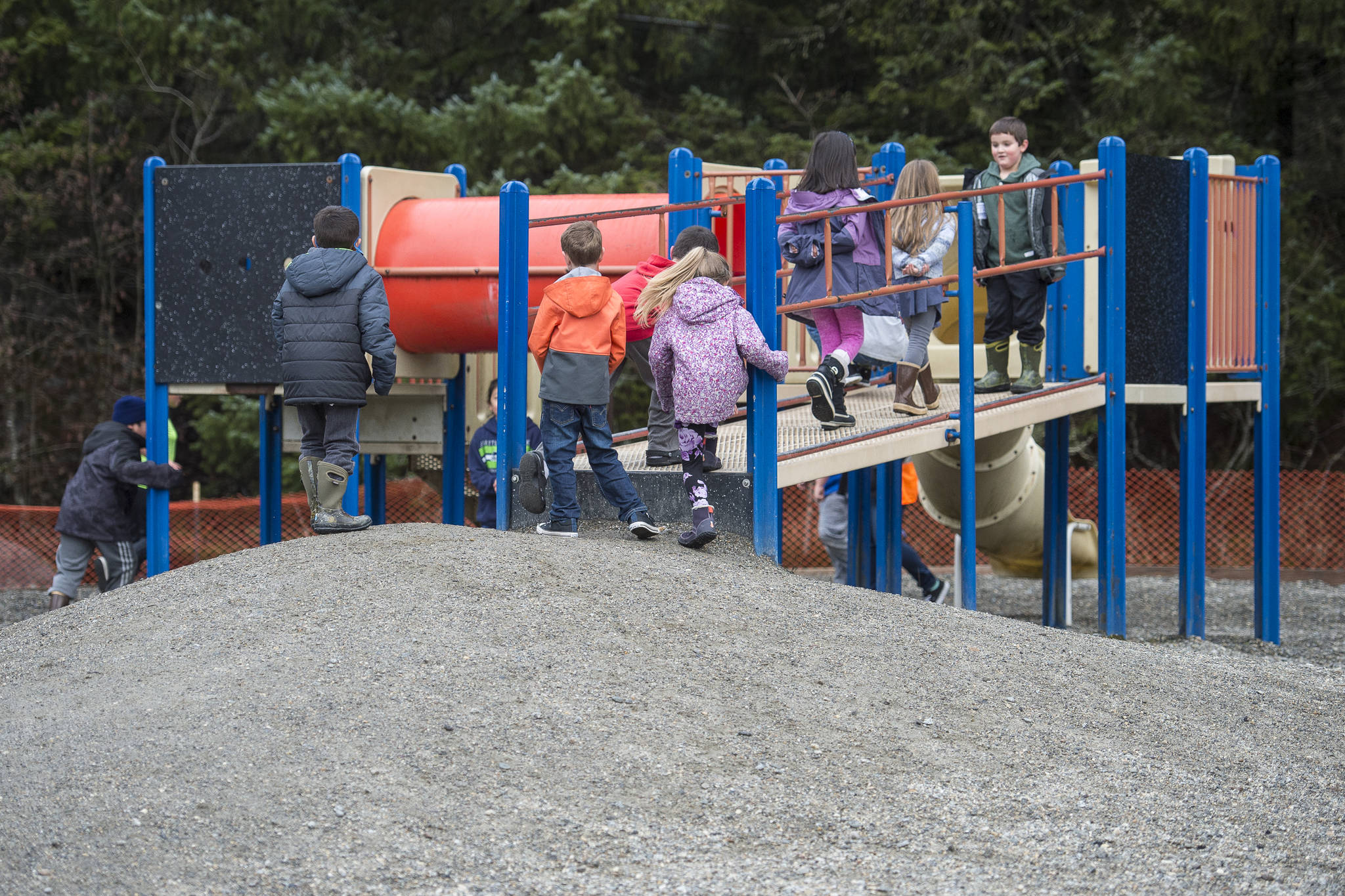 Students at Mendenhall River Elementary School run through playground equipment on Thursday, Nov. 15, 2018, that is up for replacement by the school district. The hill leading to the equipment ices up in the winter and students use the tubes to hide from yard attendants. (Michael Penn | Juneau Empire)
