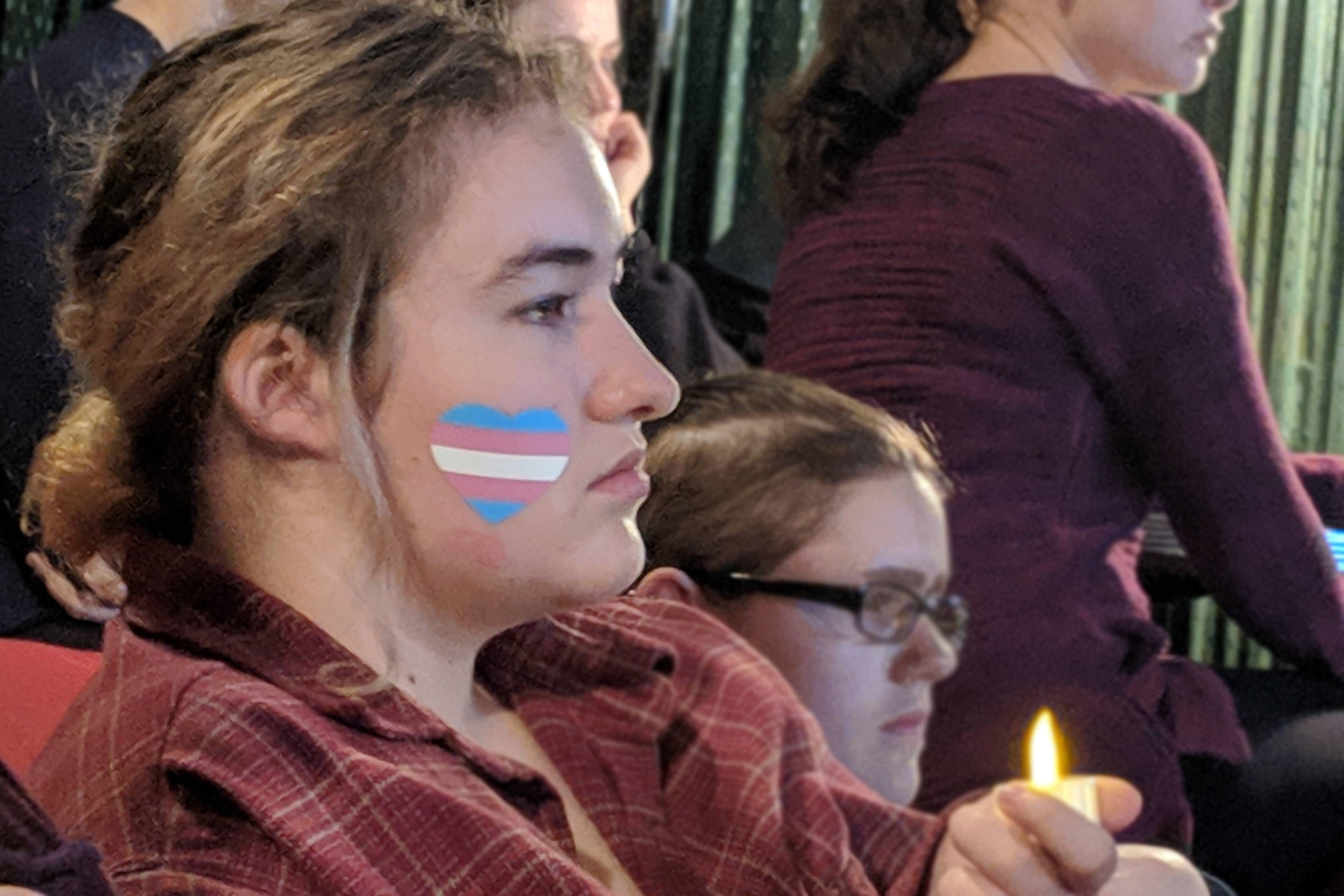 Sage Zahnd, a transgender high school student, takes in the reading of names of transgender people who were killed by violence in the U.S. during the Transgender Day of Remembrance candlelight vigil held Tuesday, Nov. 20 in Gold Town Nickelodeon. (Ben Hohenstatt | Capital City Weekly)
