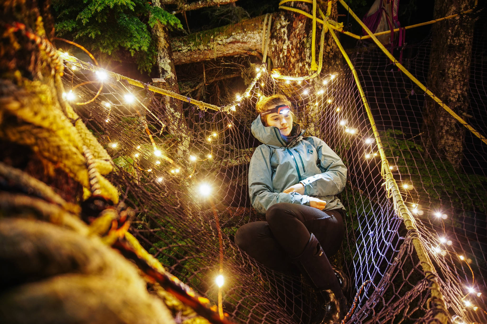 Katie McCaffrey lounges in a small pocket of the tree net. (Gabe Donohoe | For the Juneau Empire)