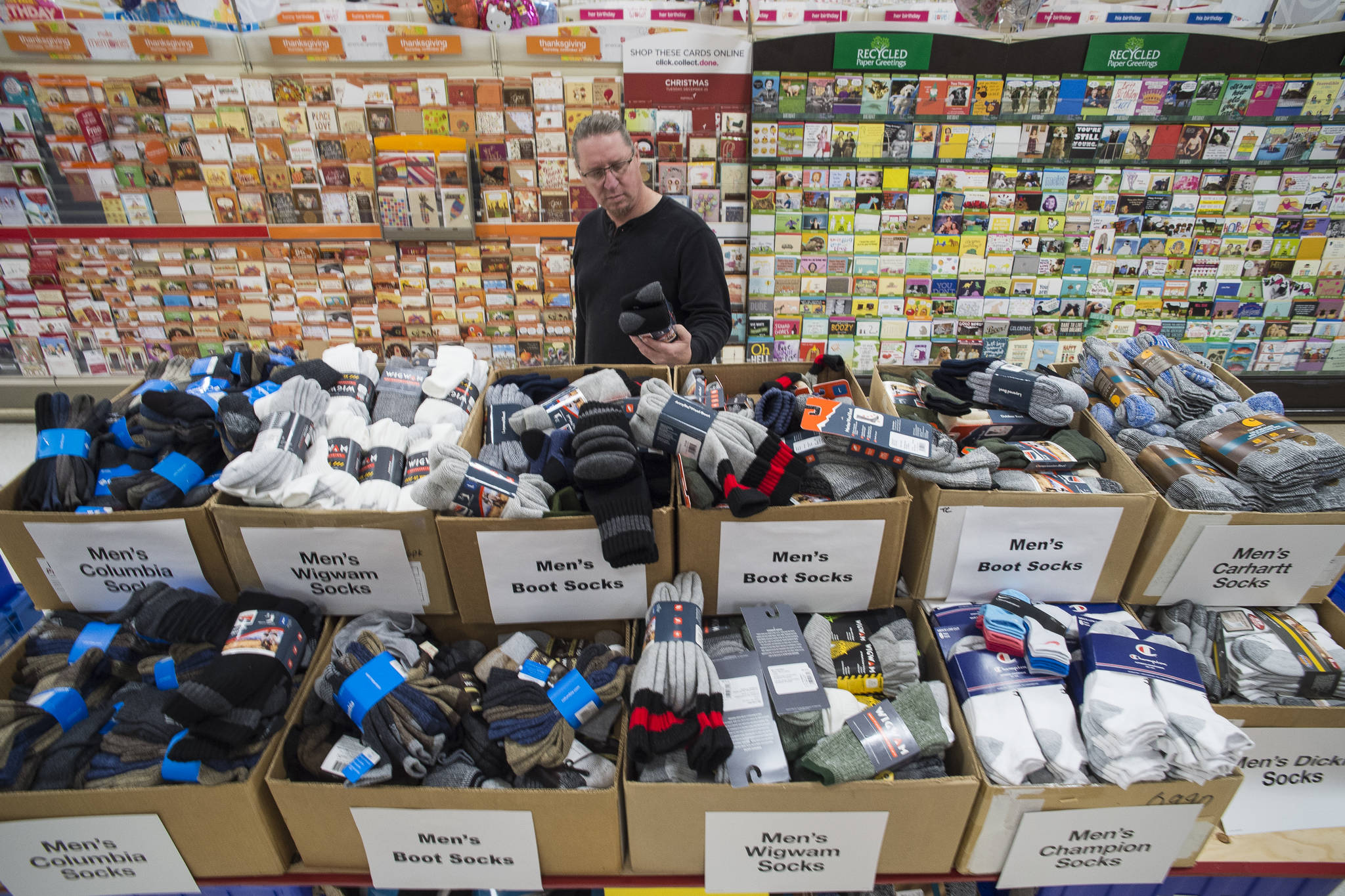 Jim Berry looks through the sock display put out for Black Friday sales at Fred Meyer on Wednesday, Nov. 21, 2018. (Michael Penn | Juneau Empire)