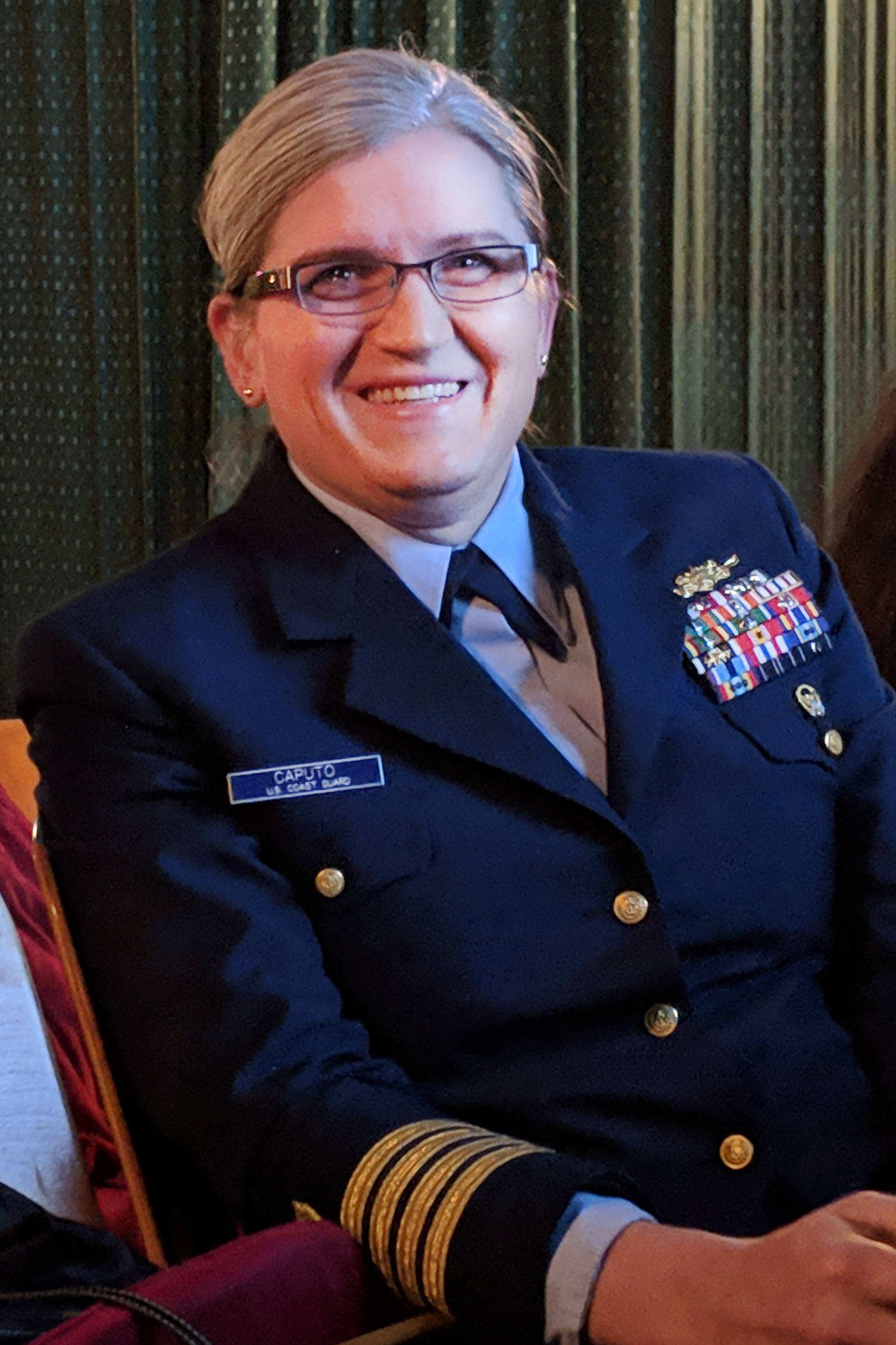 Capt. Allison Caputo smiles after a member of Juneau’s LGBTQ community delivered lighthearted marks about their experience transitioning to male Tuesday Nov. 19 at a Transgender Day of Remembrance event. Caputo’s own speech was more somber and detailed her experiences as a transgender member of the military. (Ben Hohenstatt | Capital City Weekly)