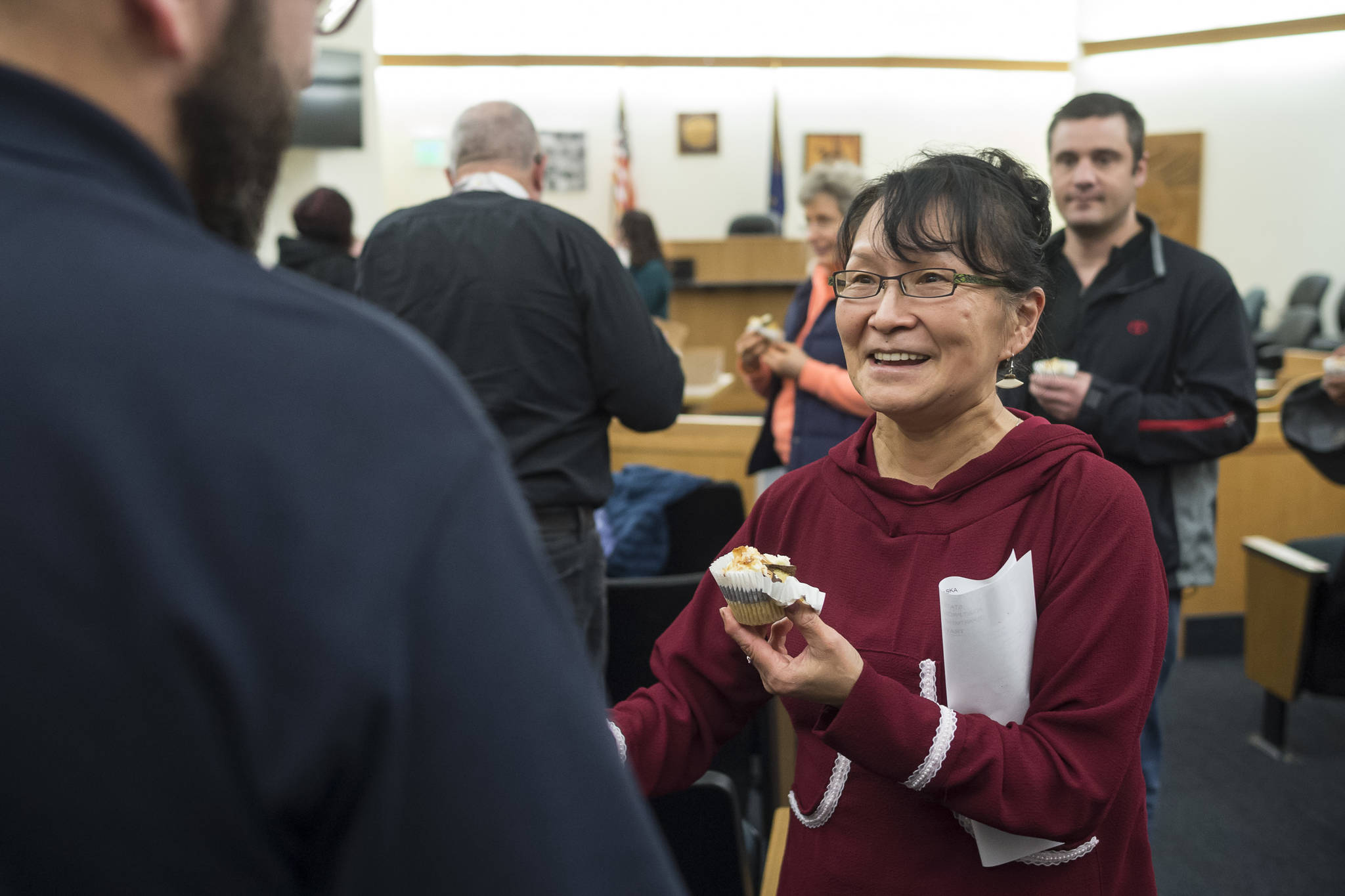 Marie Riley, a recovering alcoholic, receives congratulations and a cupcake after graduating from Juneau’s Therapeutic Court on Thursday, Nov. 15, 2018. (Michael Penn | Juneau Empire)
