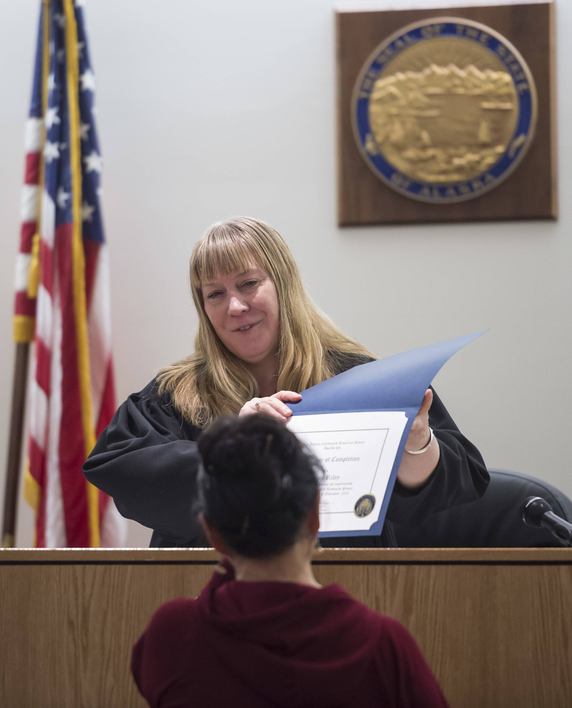 Juneau District Court Judge Kirsten Swanson presents Marie Riley, a recovering alcoholic, with a Certificate of Completion after graduating from Juneau’s Therapeutic Court on Thursday, Nov. 15, 2018. (Michael Penn | Juneau Empire)