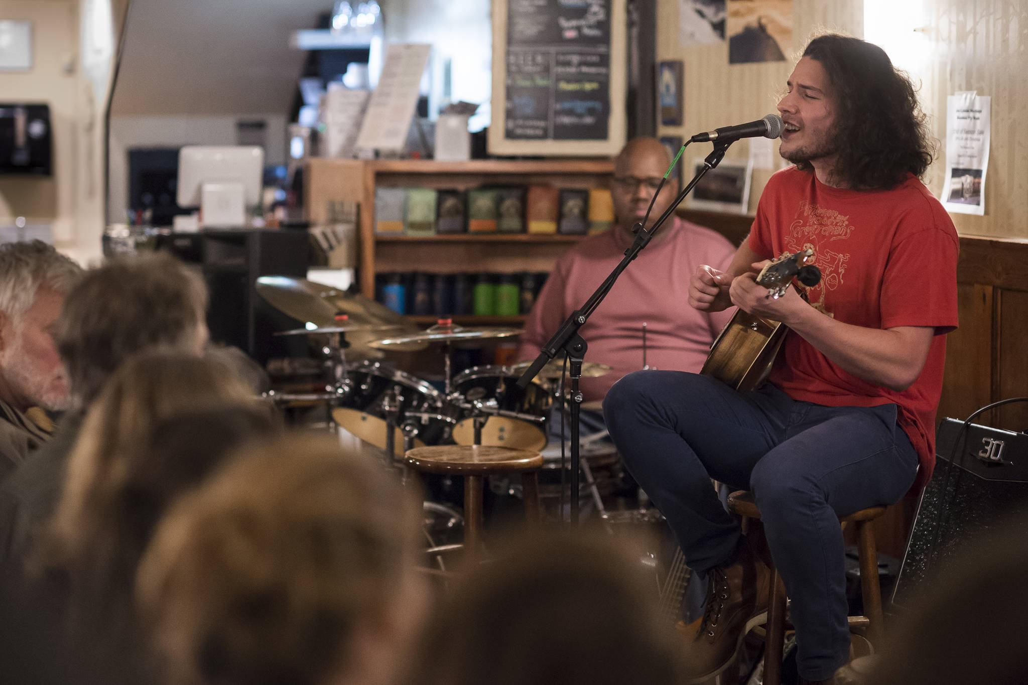 Avery Stewart plays as the featured artist at the open mic at The Rookery on Wednesday, Nov. 20, 2018. He was backed by Jason Cornish on the drum kit, Josh Lockhart on djembe and Jeff Boman on bass. (Michael Penn | Juneau Empire)