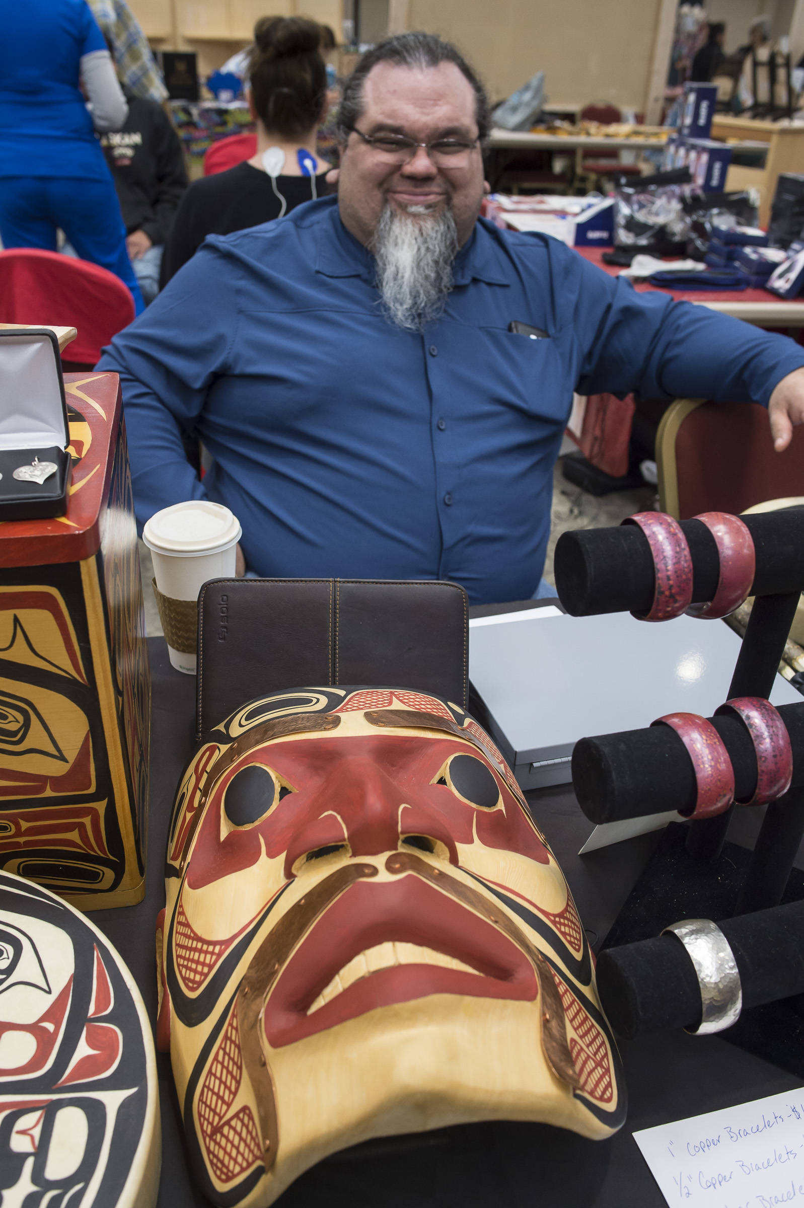 Tsimshian artist Abel Ryan waits for customers at the Public Market in the Elizabeth Peratrovich Hall on Friday, Nov. 23, 2018. (Michael Penn | Juneau Empire)