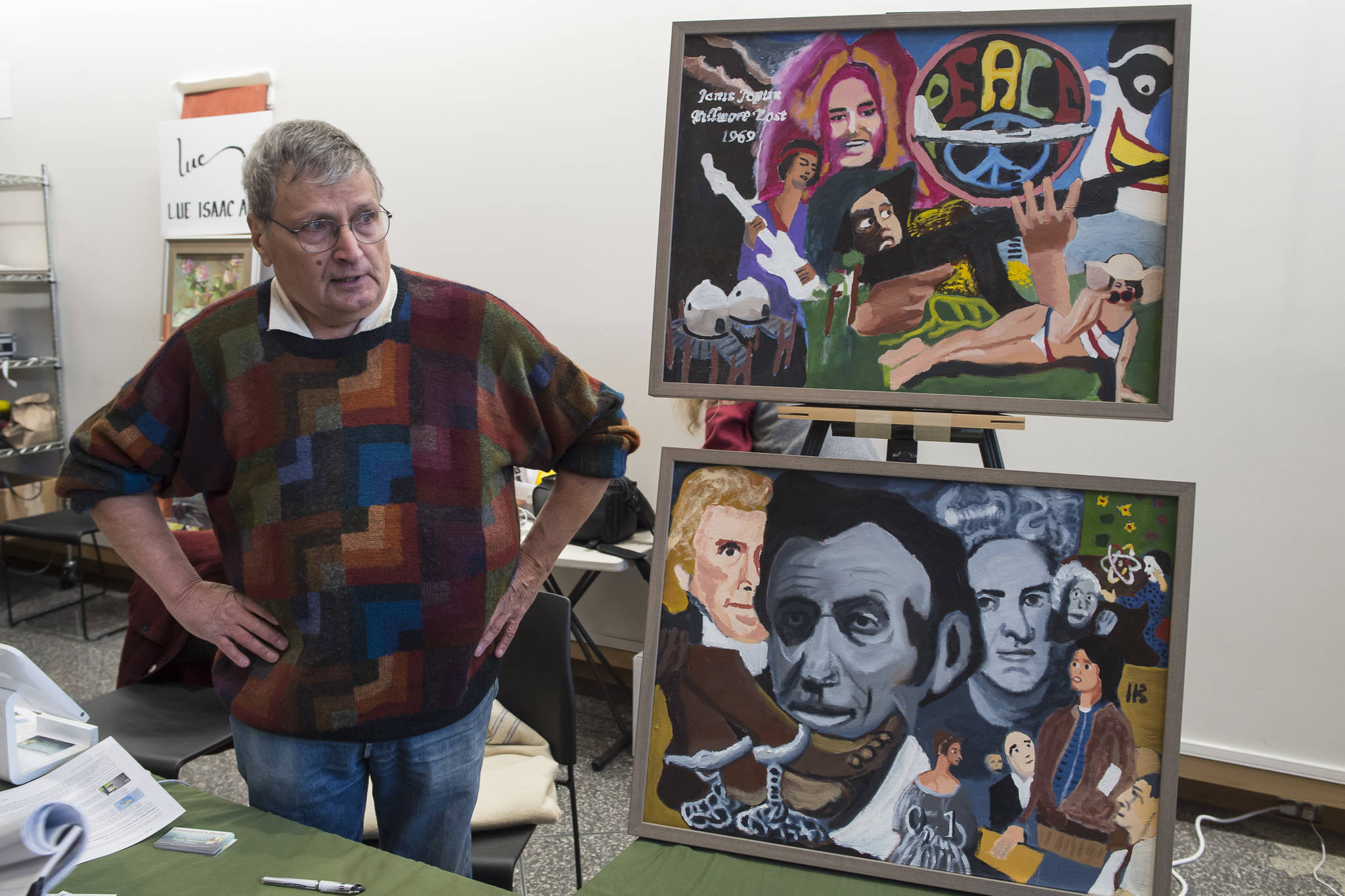 Jerry Smetzer stands next to his paintings that inspired his book “Cassiopeia’s Quest” at the Public Market in the Alaska State Museum building on Friday, Nov. 23, 2018. (Michael Penn | Juneau Empire)