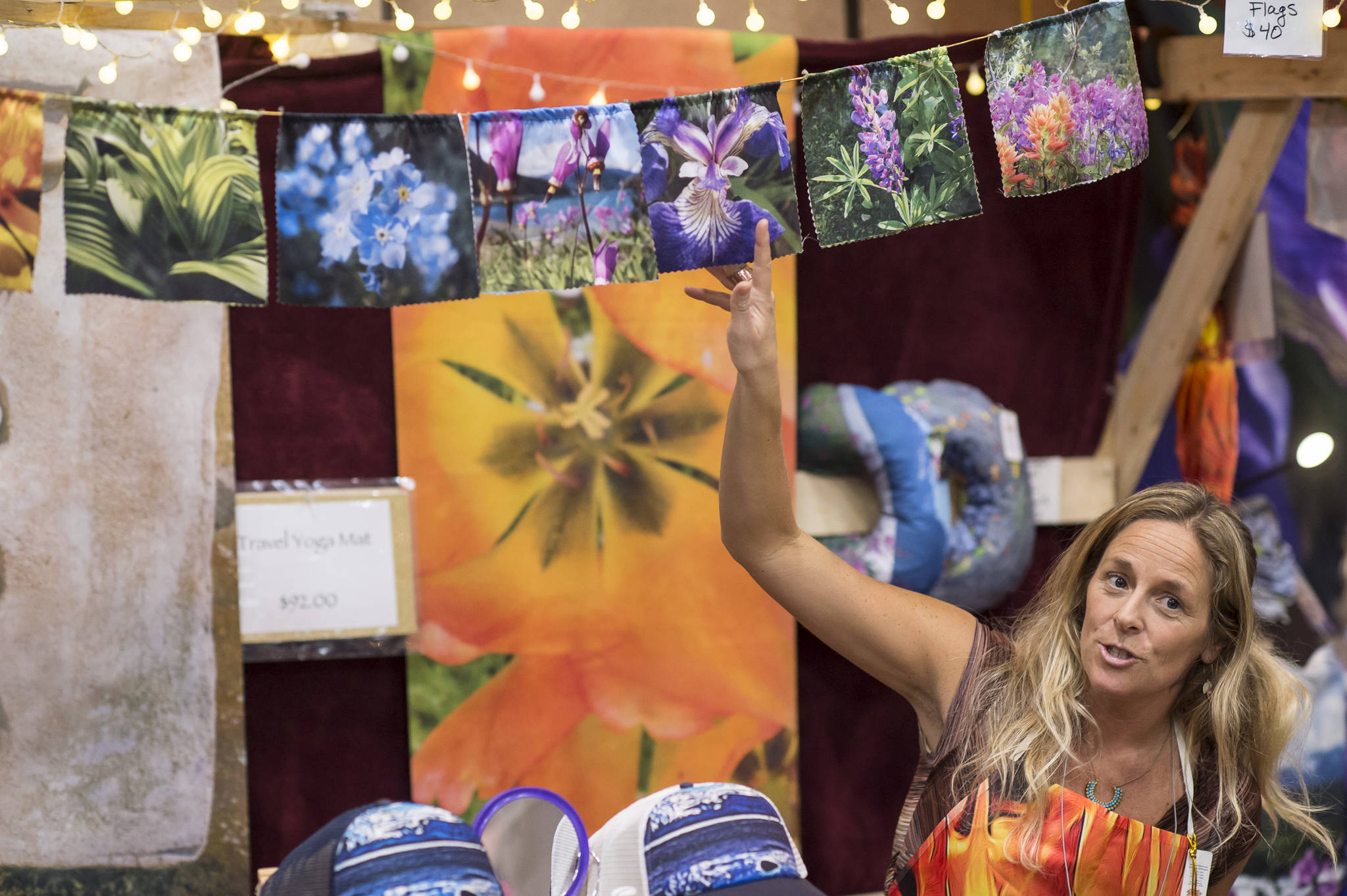 Mandy Ramsey of Soul Happy Art shows her photo prayer flags at the Public Market in Centennial Hall on Friday, Nov. 23, 2018. (Michael Penn | Juneau Empire)