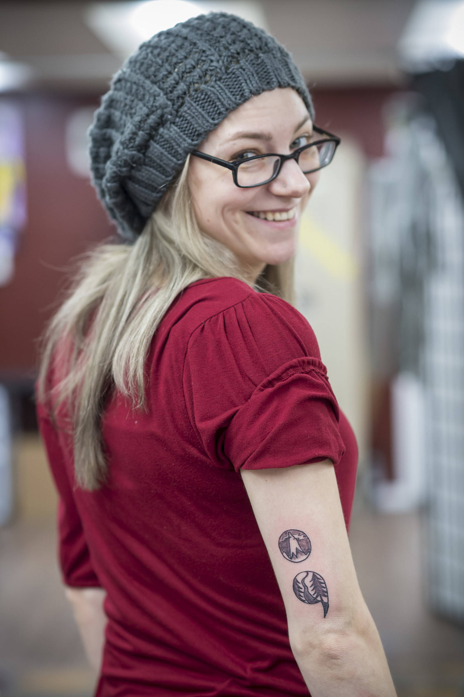 Amy Ridle displays her new stylized semicolon tattoo on her arm at Taku Tattoo on Monday, Nov. 19, 2018. (Michael Penn | Juneau Empire)