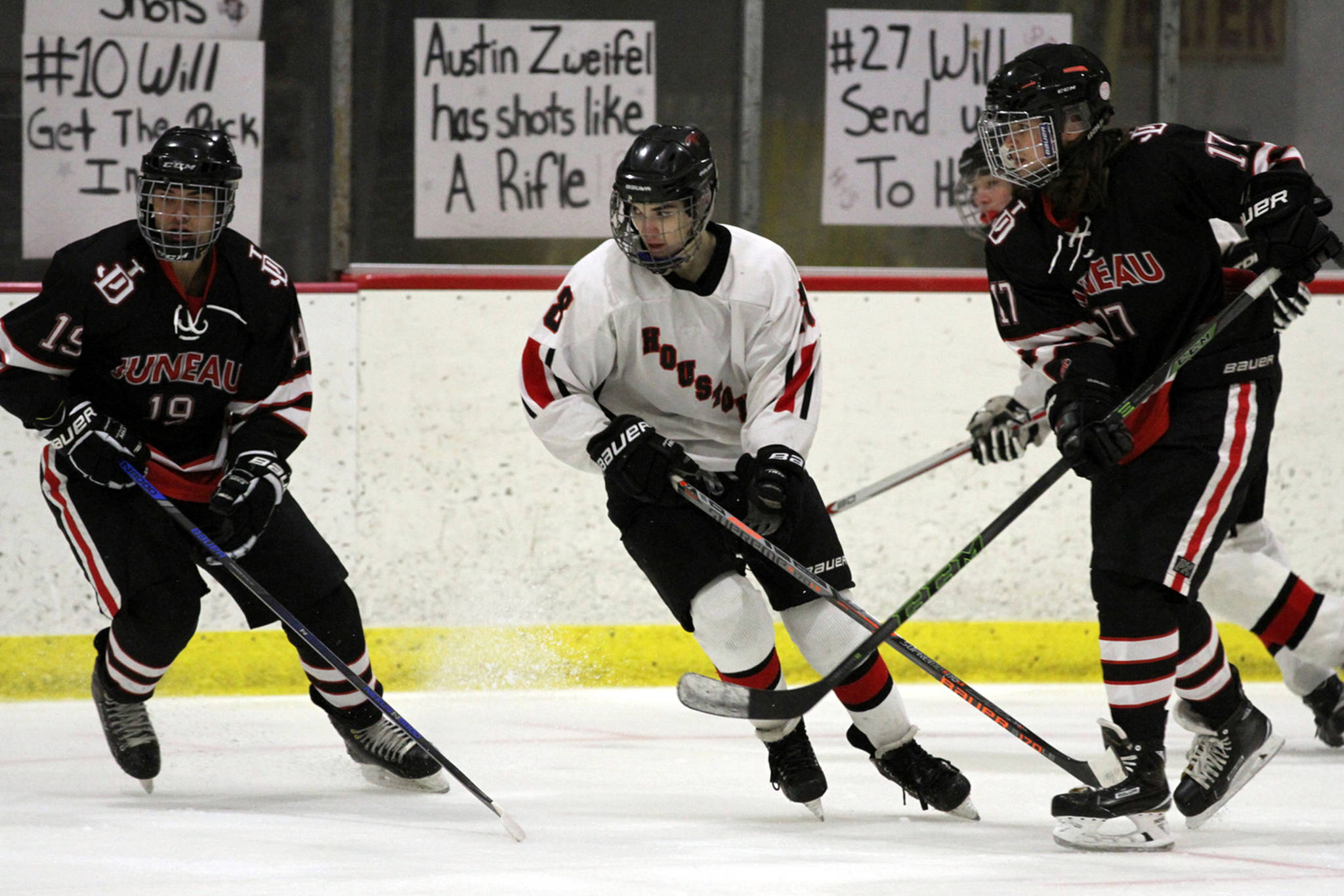 Houston’s Austin Zweifel skates in between Juneau-Douglas’ Ronan Lynch, left, and Bill Bosse, right, during the Big Lake Lions Christmas Classic Tournament last December in the Big Lake. Houston, who won the game 2-1, has a long history with JDHS. (Courtesy Photo | MatSuSports.net)