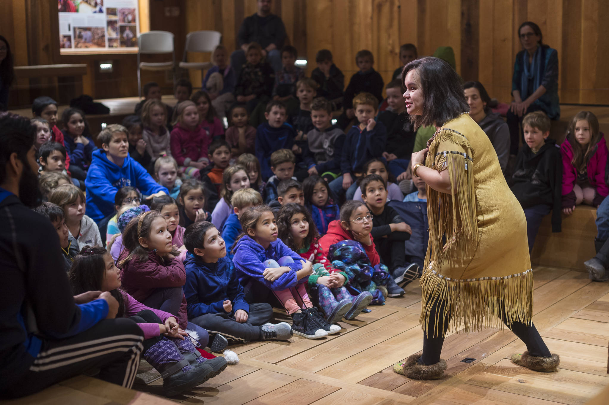 Lily Hope tells a story of raven, king salmon and the birds to second grade students from Harborview Elementary, Montessori Borealis and Juneau Charter Community School at the Walter Soboleff Center on Friday Nov. 30, 2018. The Storytelling Excursion for all Juneau School District second graders is part of the Any Given Child programming sponsored by the Juneau School District, Mayor’s office, University of Alaska Southeast, Sealaska Heritage Institute and the Juneau Arts and Humanities Council. (Michael Penn | Juneau Empire)