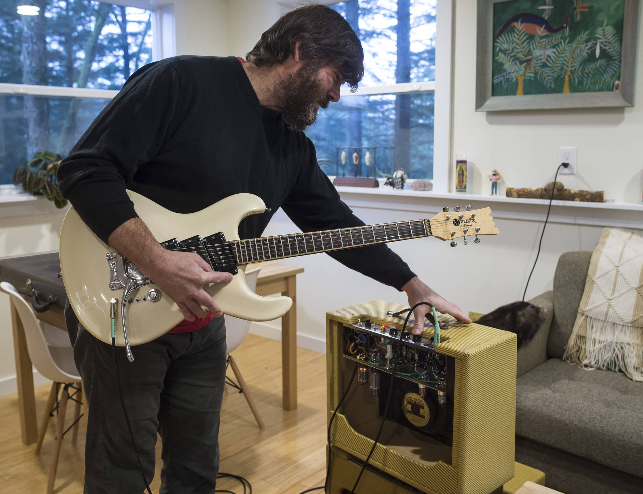 Reber Stein talks Wednesday, Dec. 5, 2018, about making tube amplifiers for his friends. Stein has been tinkering with the guitar amplifiers that make use of vacuum tubes for about a decade. While Stein uses guitars to test his amps, he said learning to play remains a goal. (Michael Penn | Juneau Empire)