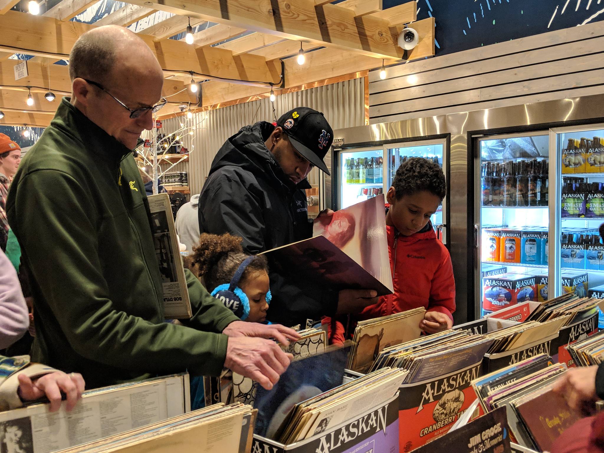 Tom Meyer, James Hunter and Jasiah Hunter look through records at a pop-up record shop Thursday, Dec. 6. (Ben Hohenstatt | Capital City Weekly)