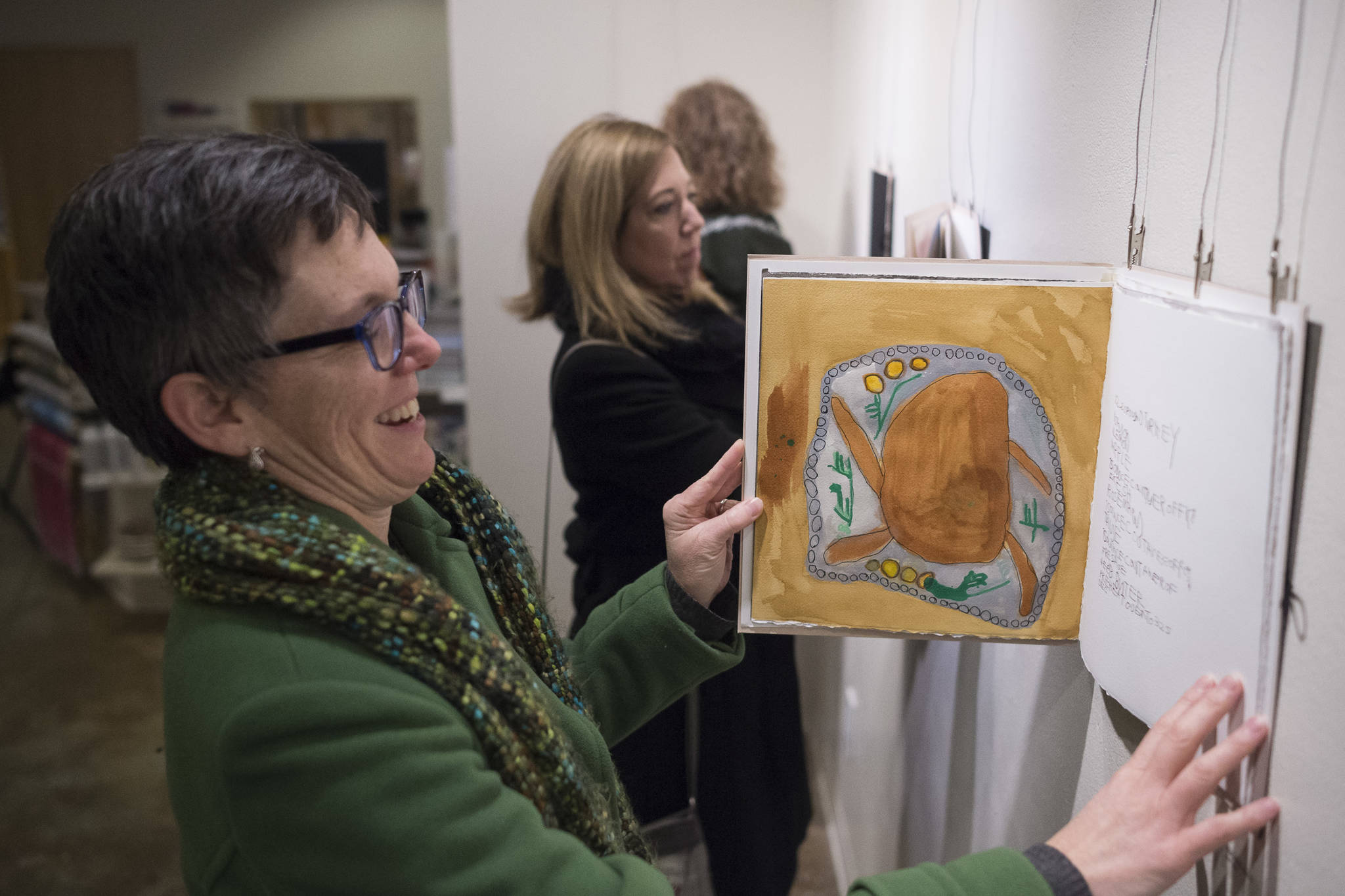 Kim Champney views new works featuring The Canvas artists’ Sketchbook Show during Gallery Walk on Friday, Dec. 7, 2018. (Michael Penn | Juneau Empire)