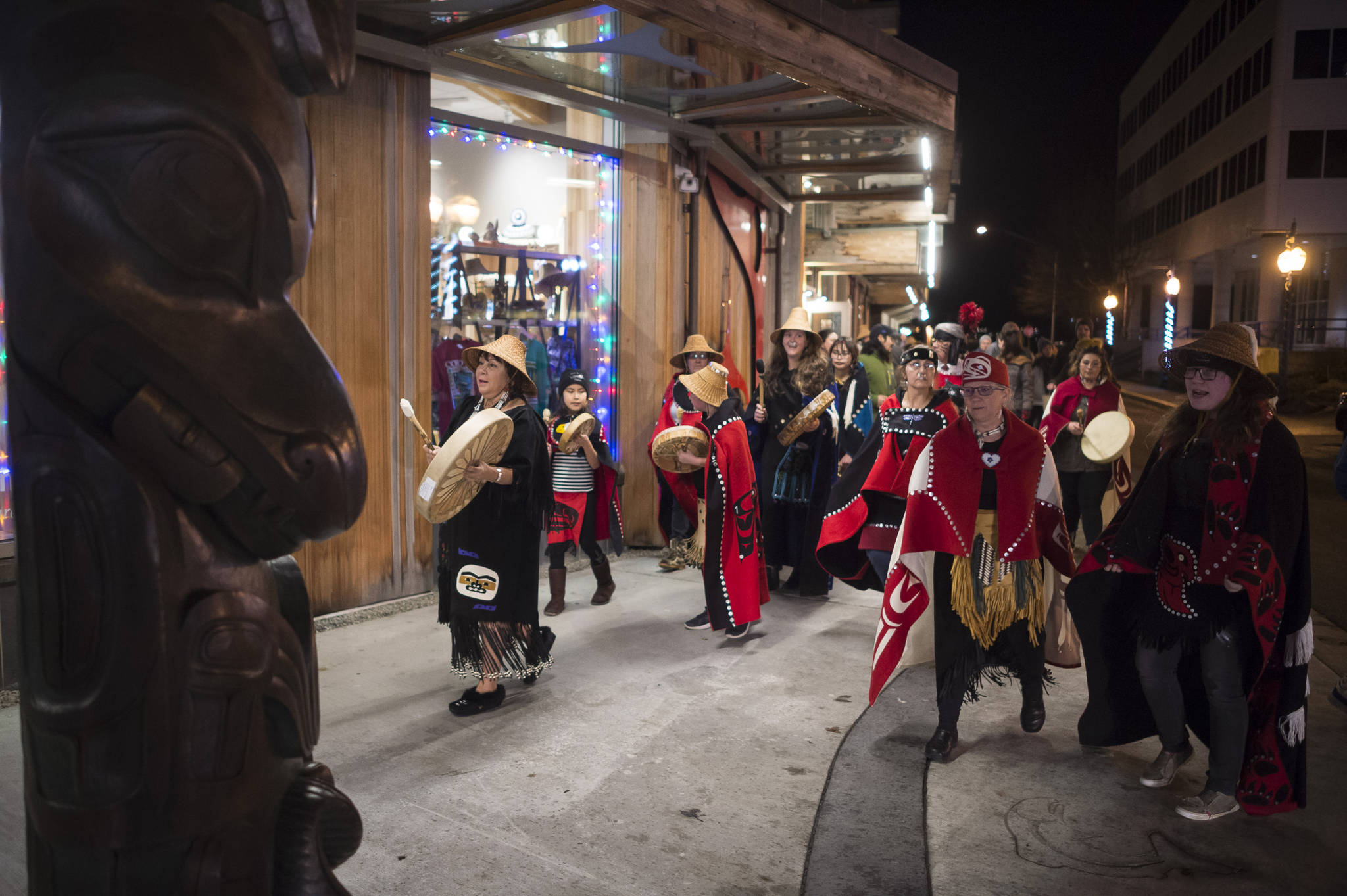 Nancy Barnes, left, leads the multicultural dance group Yees Ku Oo to Front Street to dance during Gallery Walk on Friday, Dec. 7, 2018. (Michael Penn | Juneau Empire)