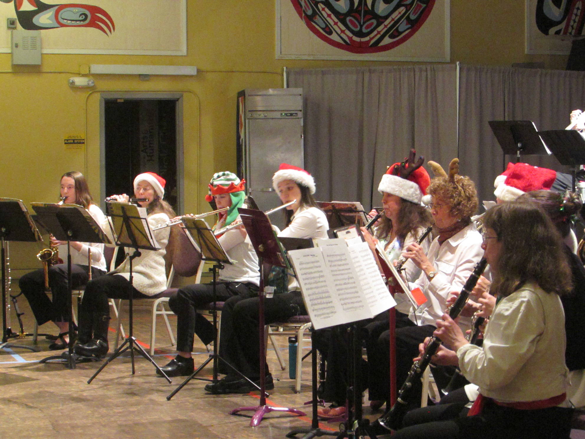 Taku Winds players donned Santa hats, reindeer antlers and elf caps for the closing number during the Homemade for the Holidays concert Saturday, Dec. 8, 2018. (Ben Hohenstatt | Capital City Weekly)