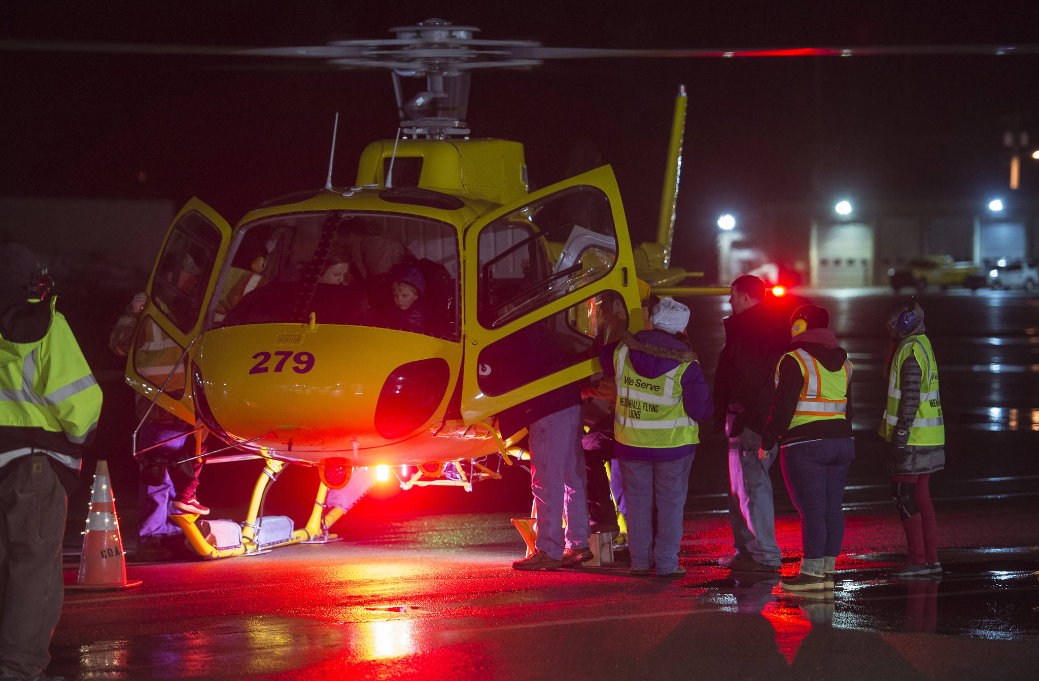Juneauites board a Coastal Helicopter for the annual Christmas Lights Flights at the Juneau International Airport on Friday, Dec. 15, 2017. Mendenhall Flying Lions put on the event, which is a fundraiser for the American Children’s Tumor Foundation. Petro Marine Services and Coastal Fuel also support the event. (Michael Penn | Juneau Empire File)