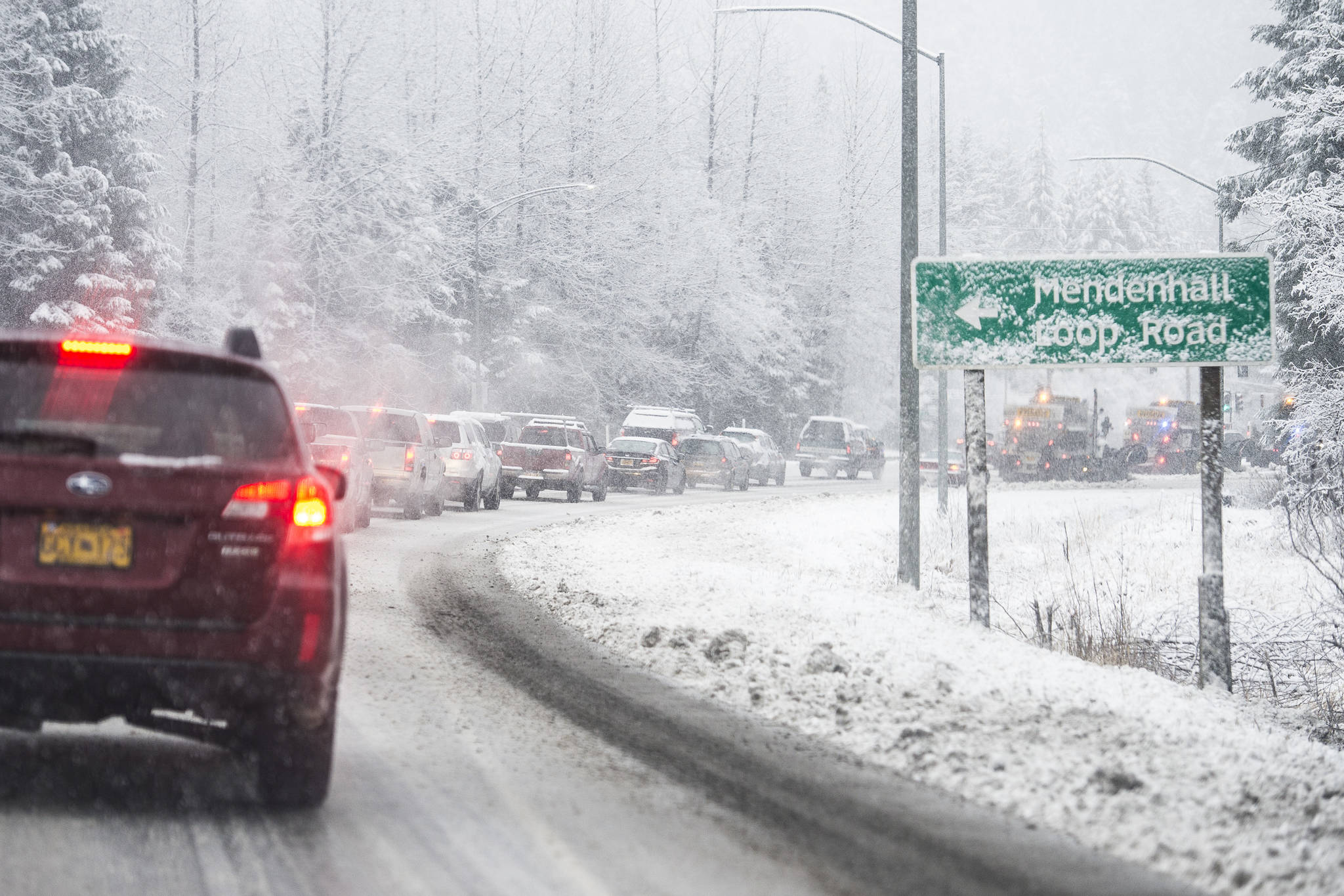 Traffic backs up behind state snow plow trucks during snow fall on Thursday, Dec. 13, 2018. (Michael Penn | Juneau Empire)