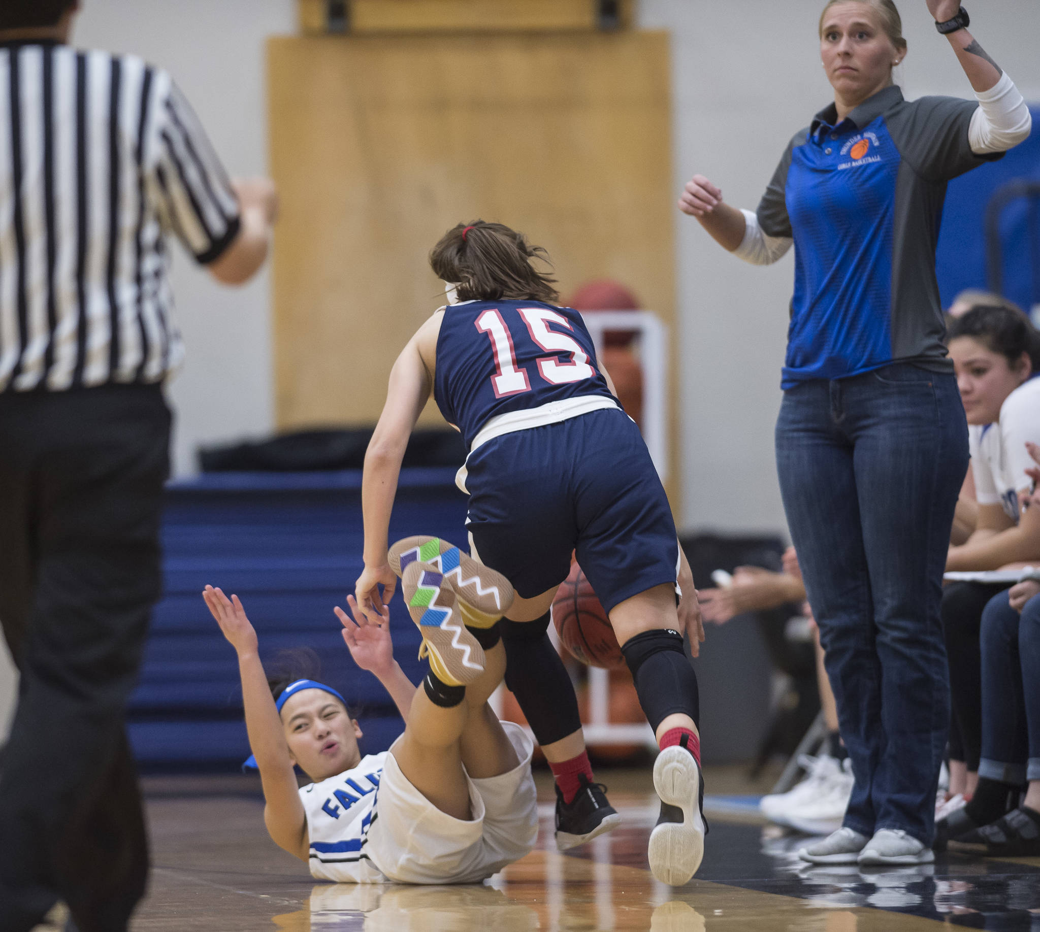 Thunder Mountain’s Mary Neal Garcia falls and is called for a foul against North Pole’s Laura Donovan at TMHS on Thursday, Dec. 13, 2018. (Michael Penn | Juneau Empire)