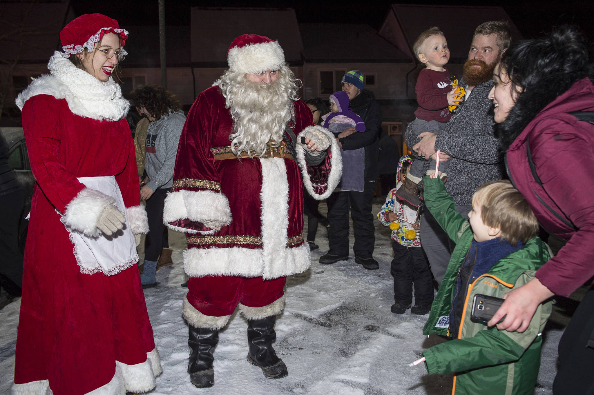 Mr. and Mrs. Claus stop to visit families at Cedar Park during the annual Capital City Fire/Rescue Santa Parade on Friday, Dec. 14, 2018. (Michael Penn | Juneau Empire)