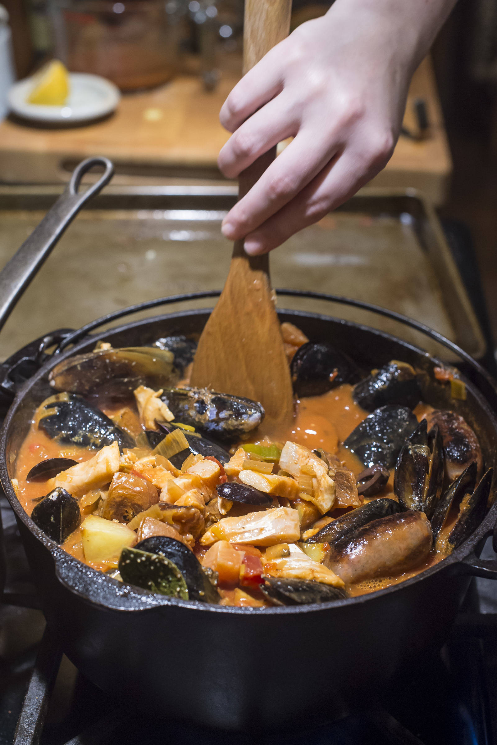 Erin Anais Heist prepares her tomato-based Portuguese fisherman’s stew with a variety of seafood, spicy sausage, potatoes and smoked paprika in her home kitchen on Friday, Dec. 14, 2018. (Michael Penn | Juneau Empire)