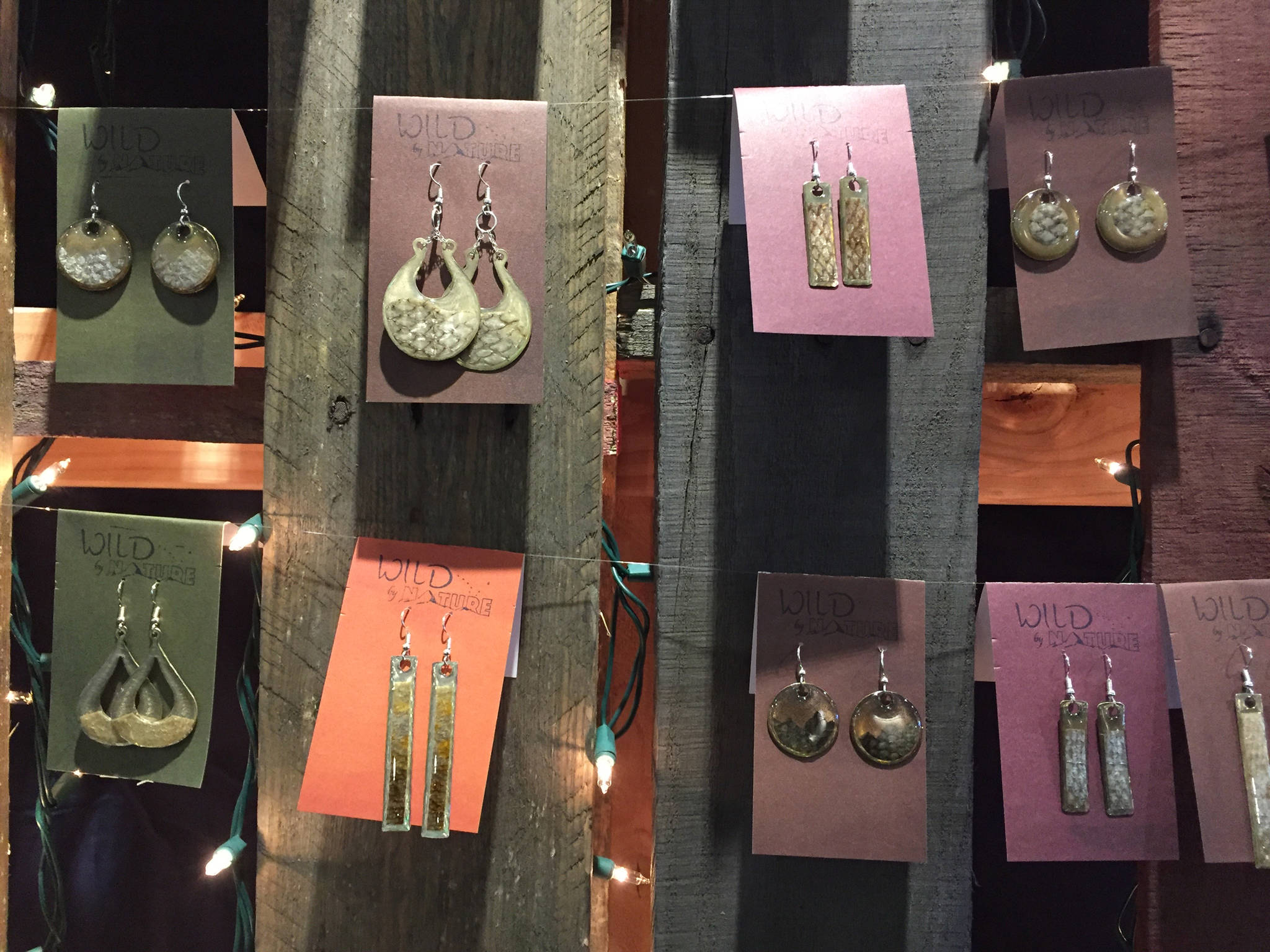 Earrings created using the skin of salmon and other wild Alaska fish, created by Juneau artist Julienne Pacheco, are on display at Juneau’s Public Market in November of 2017. (Mary Catharine Martin | SalmonState)