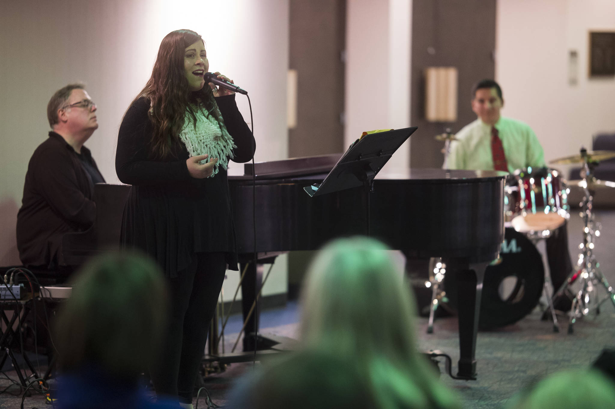 Juneau Cabaret singer Alyssa Fischer sings for Juneau residents as she is accompanied by Tom Locher and David Sheakley-Early during the third annual Holiday Extravaganza at Centennial Hall on Wednesday, Dec. 19, 2018. (Michael Penn | Juneau Empire)