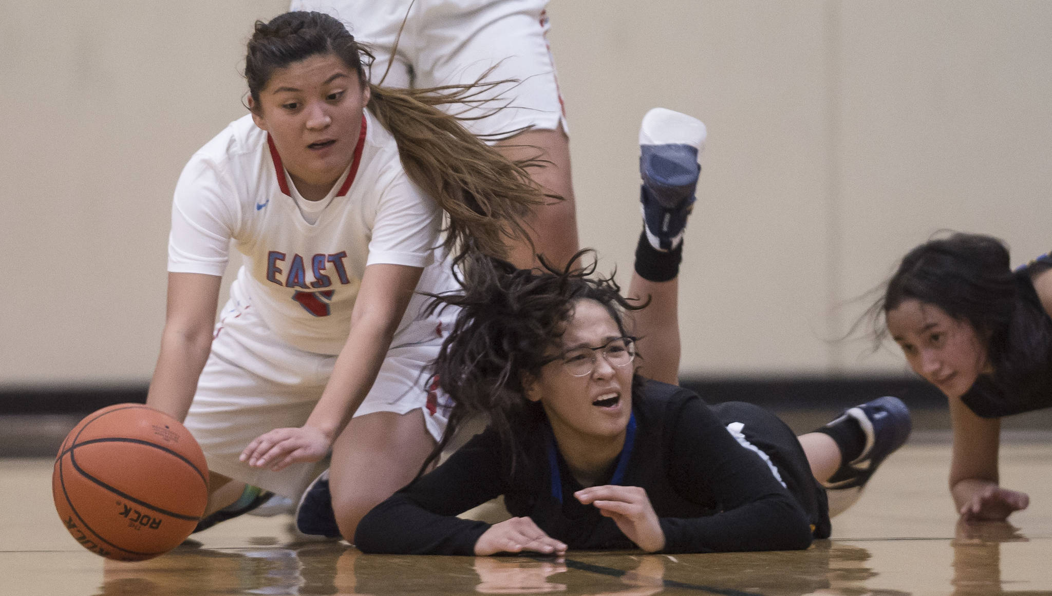 East’s Jayla Jordan, left, and Barrow’s Caitlyn Brower, center, and Justine Balanza scramble for the loose ball at the Princess Cruises Capital City Classic at Juneau-Douglas High School on Thursday, Dec. 27, 2018. (Michael Penn | Juneau Empire)