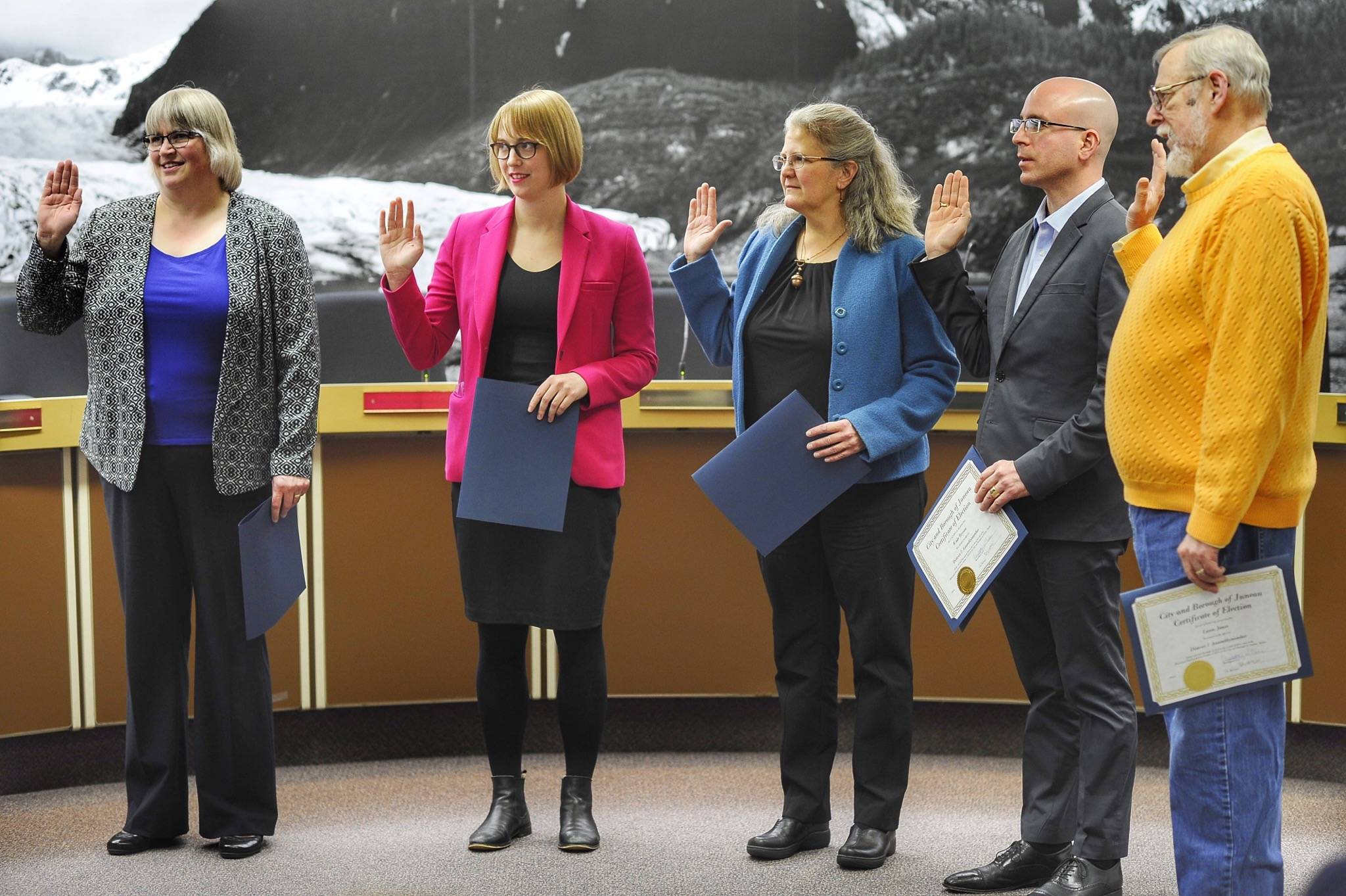 Mayor Beth Weldon, left, Carole Triem, Michelle Bonnet Hale, Wade Bryson and Loren Jones are sworn in to their new positions on the Juneau Assembly on Monday, Oct. 15, 2018. (Michael Penn | Juneau Empire)