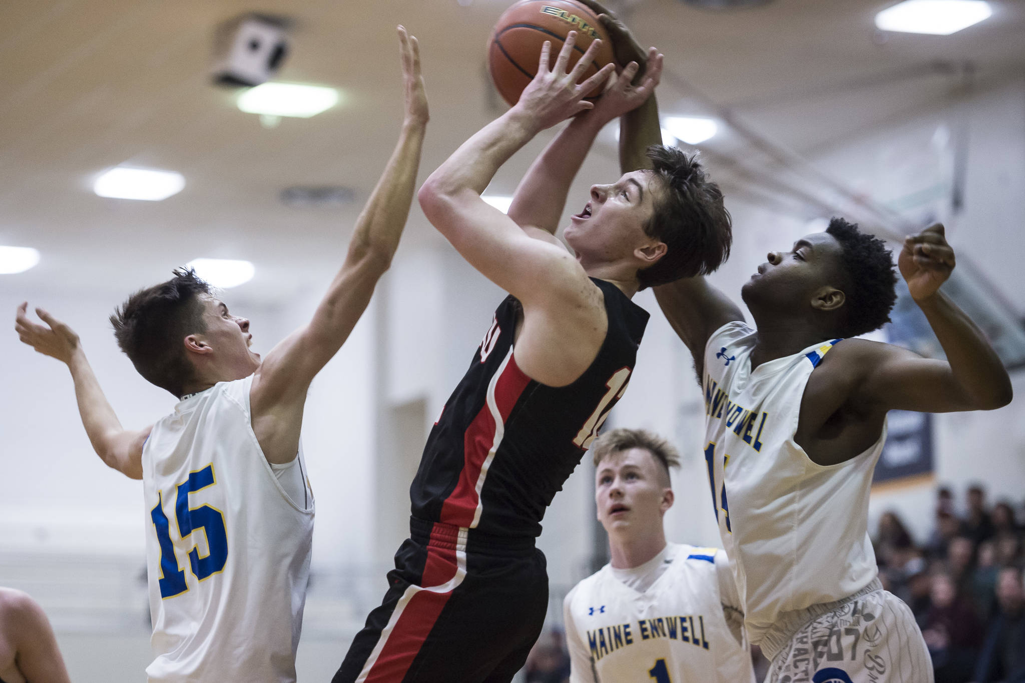Juneau-Douglas’ Brock McCormick, center, is blocked by Maine-Endwell’s Jordan Gallagher, left, and Kameron Griggs at the Princess Cruises Capital City Classic at Juneau-Douglas High School on Saturday, Dec. 29, 2018. Juneau-Douglas won 66-61. (Michael Penn | Juneau Empire)